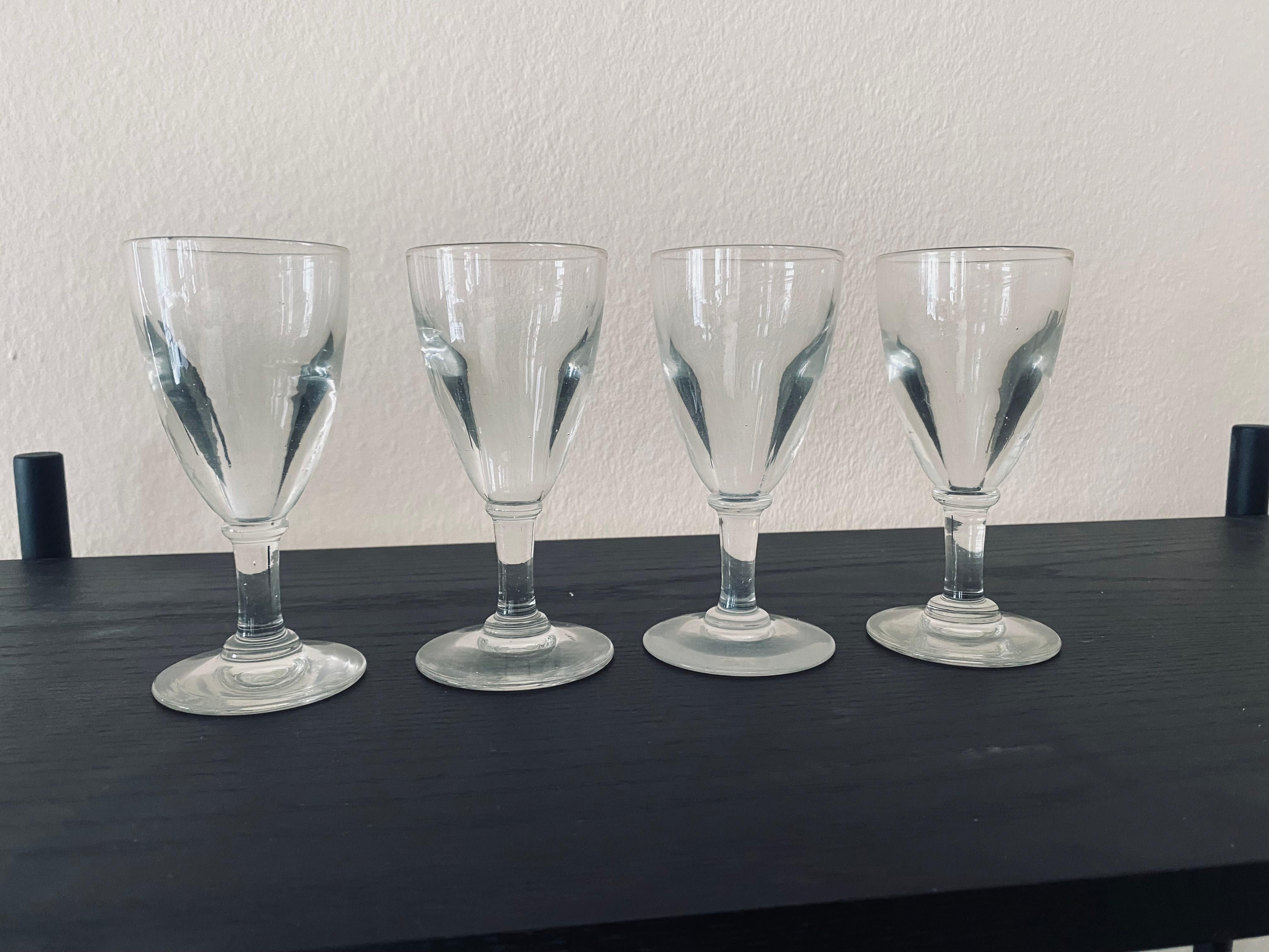 Introducing our exquisite set of 4 Pasties glasses from France, dating back to the enchanting era of 1900. Crafted with meticulous artistry, these glasses boast a remarkable weightiness, thanks to the thick, veined antique glass that was expertly