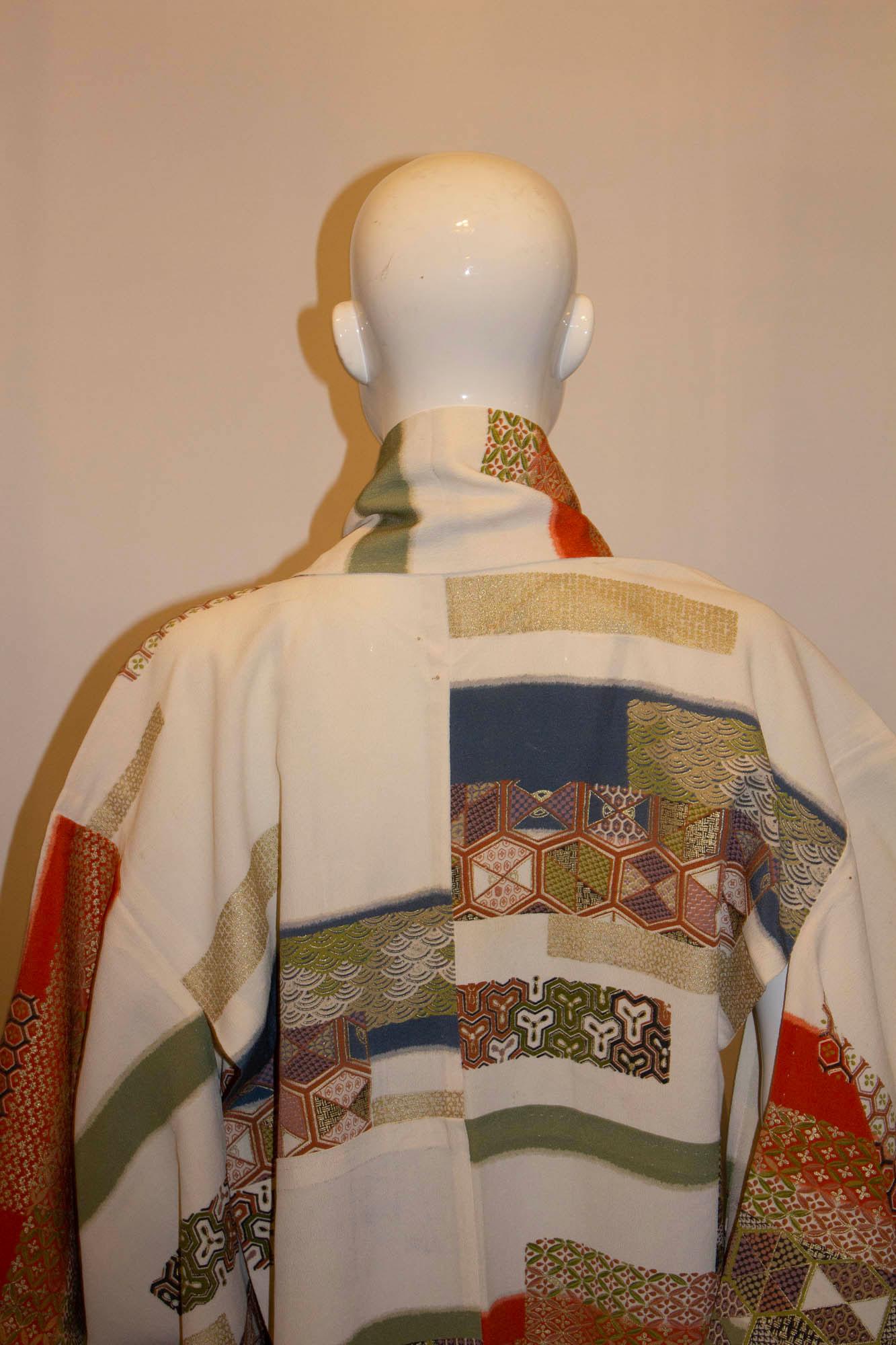 A fun vintage kimono for Spring. The kimono has an ivory background with multicolour and gold patch design on the front and back . It is unlined. Measurements: Bust up to 48'', length 64''