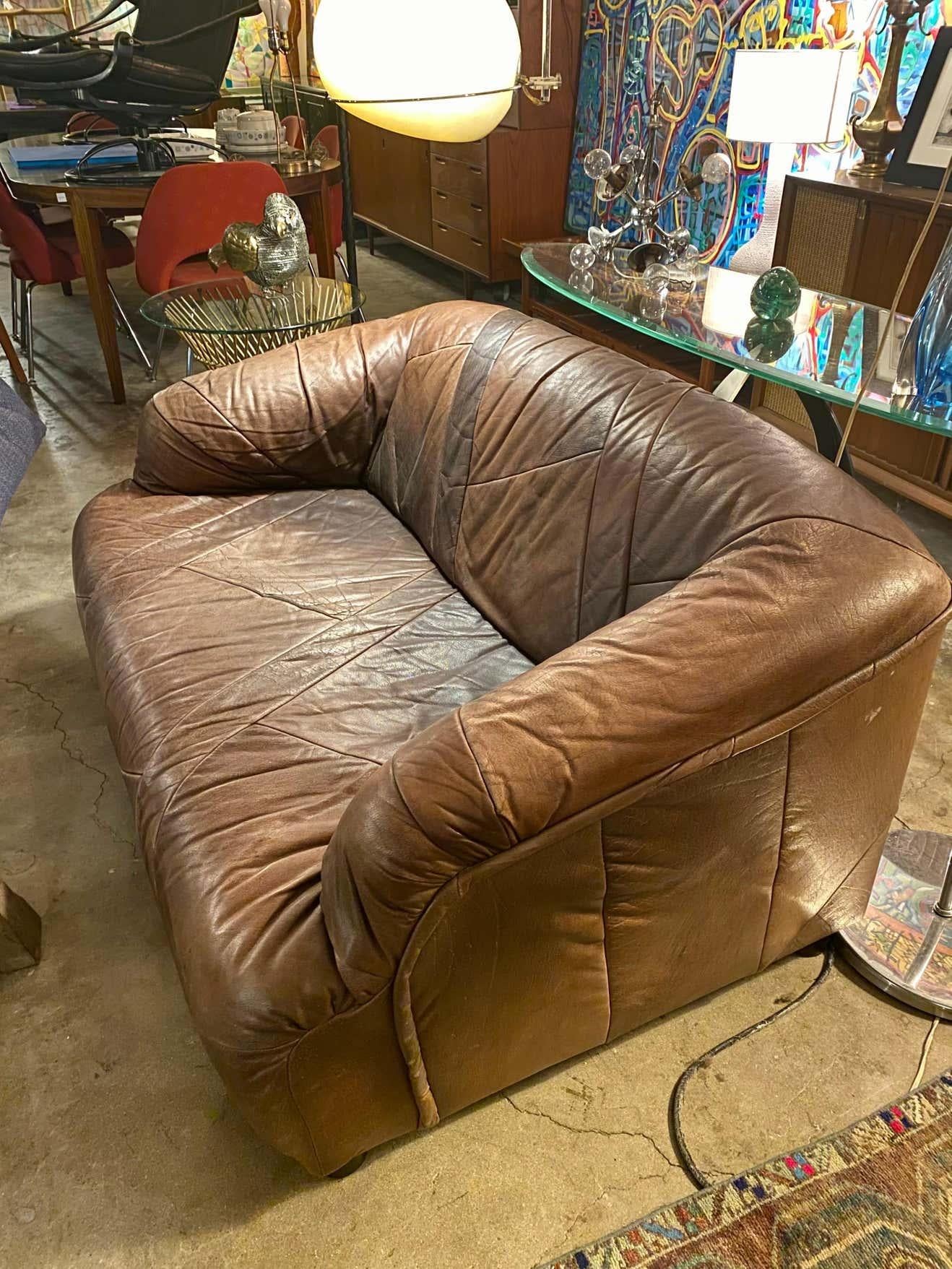 Fantastic vintage patchwork loveseat and chair in a dark brown patchwork leather upholstery, Germany, circa 1970s. Great patina with some wear on the back right side of of the chair. Overall this vintage loveseat and chair are in good condition.