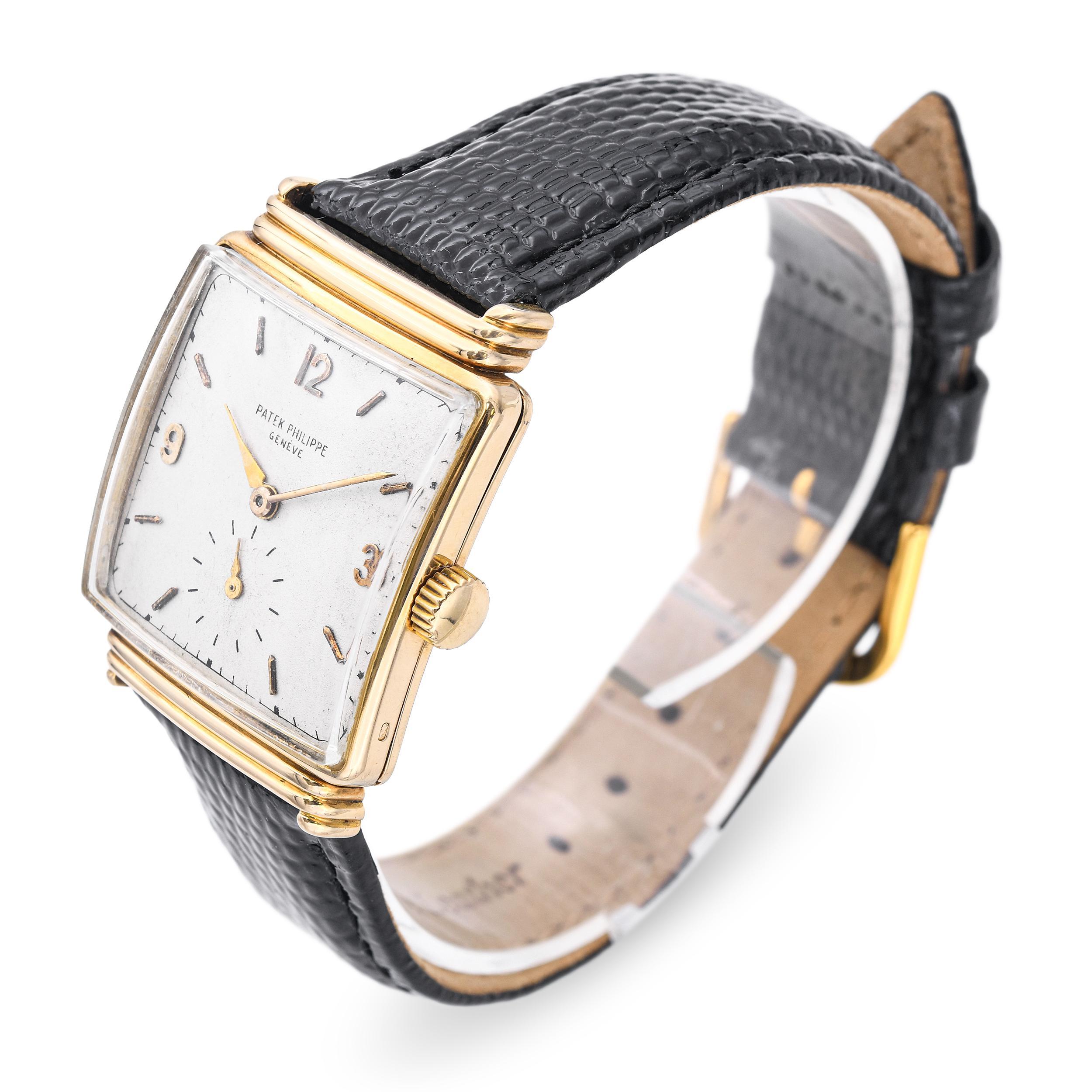 Un raffinato orologio vintage da uomo Patek Philippe realizzato in oro giallo massiccio 18 carati, caratterizzato da una cassa quadrata con bordi a gradini di ispirazione Déco. Il quadrante argentato invecchiato mostra numeri arabi dorati alle 12 e