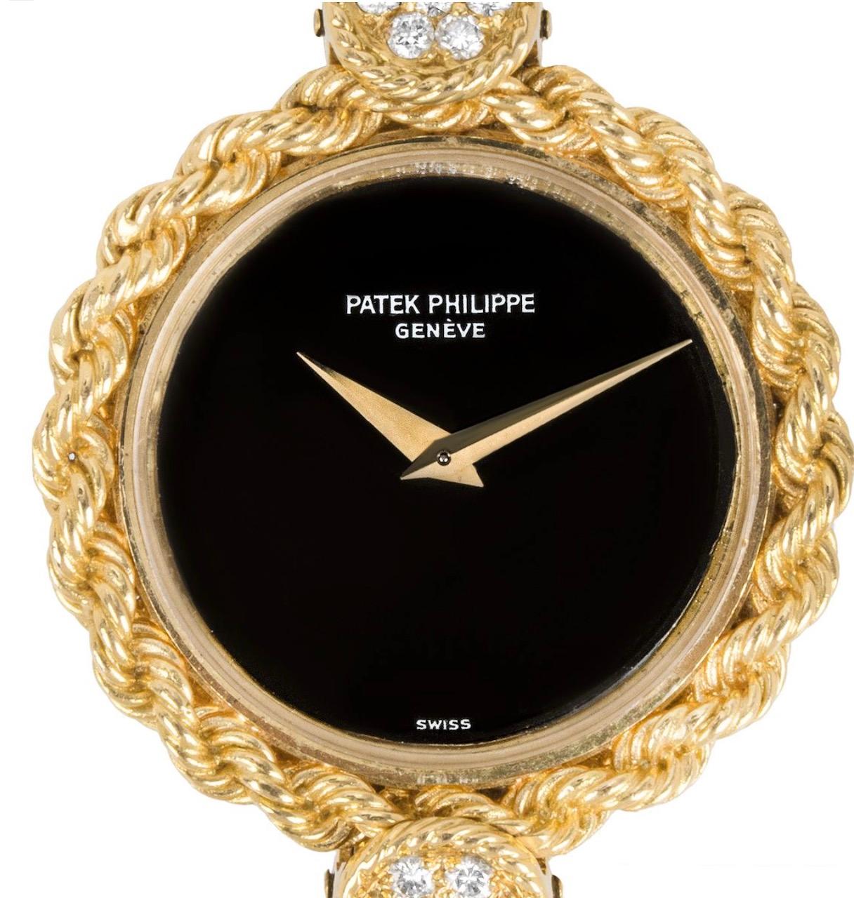 Une superbe montre habillée vintage pour femme, en or jaune, de Patek Philippe. Le cadran est en onyx noir et la lunette en corde d'or torsadée.

Le bracelet est doté d'un maillon en forme de disque serti d'un motif en onyx et en malachite, séparé