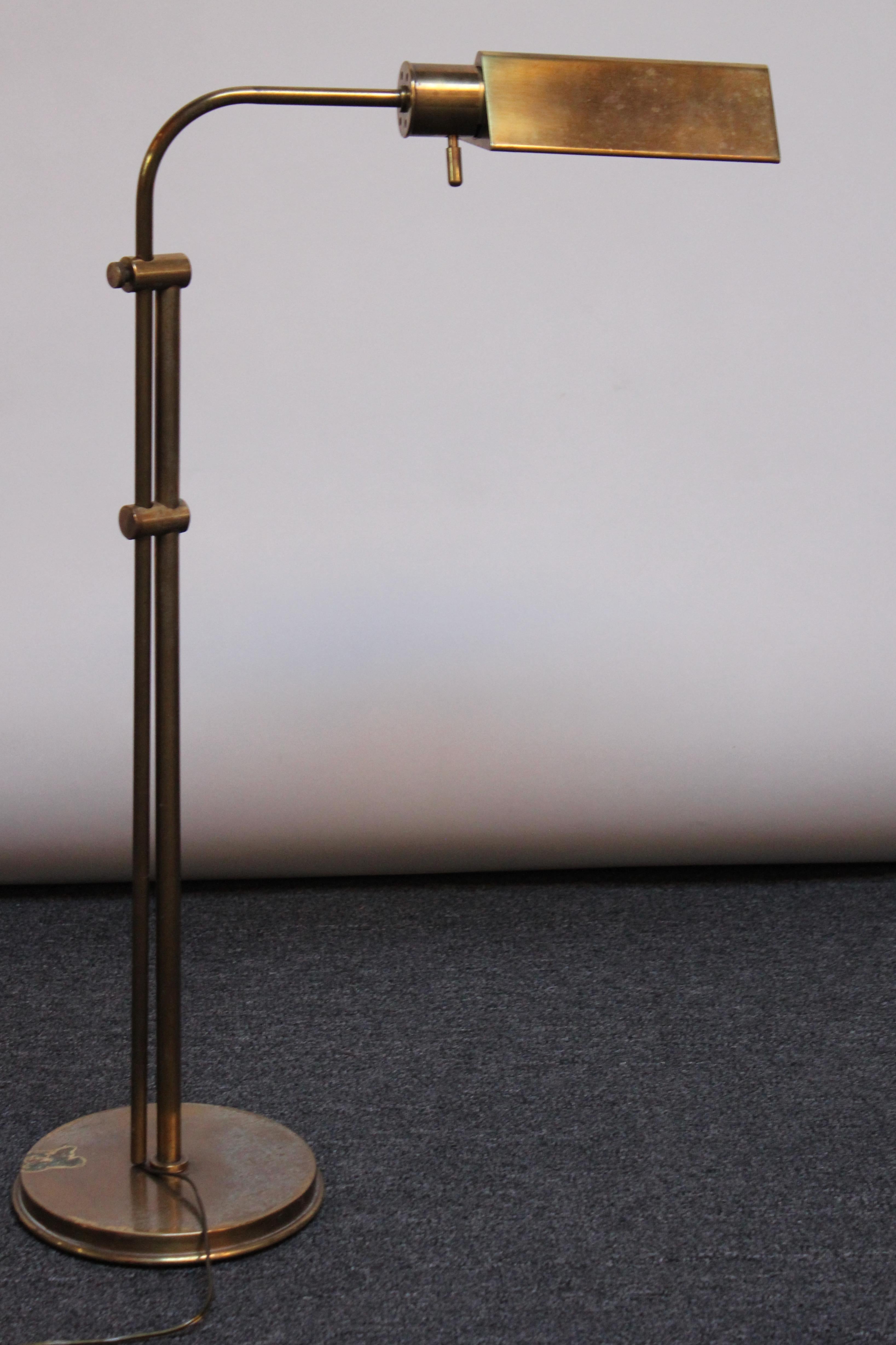 Lampadaire Chapman en laiton avec abat-jour triangulaire, base ronde et interrupteur 'capsule' (1970, USA). L'abat-jour est entièrement réglable, offrant une mobilité totale à 360 degrés, ainsi qu'un bras pivotant avec une hauteur totale réglable de