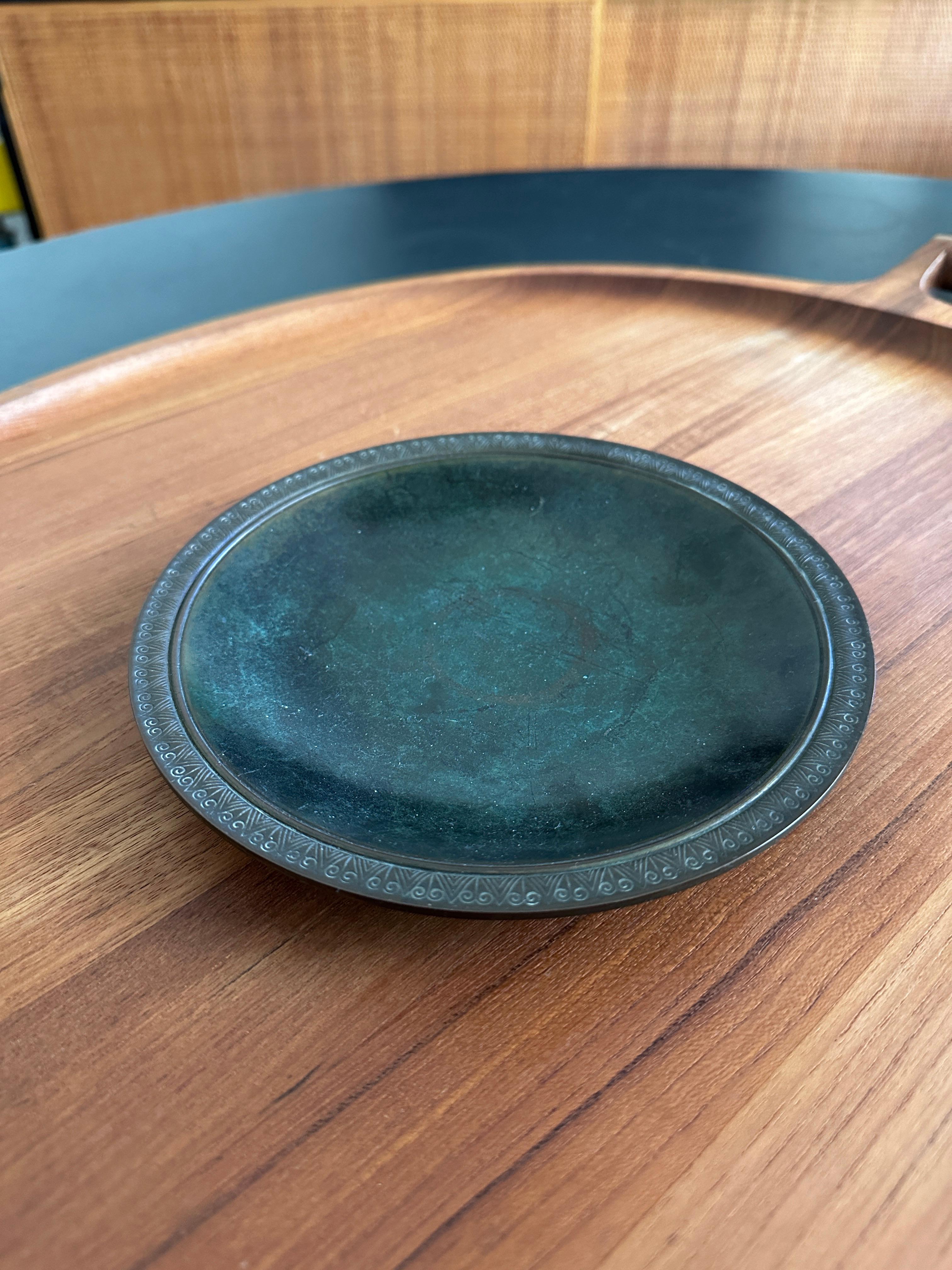 A beautiful patinated bronze shallow bowl designed by Just Andersen. The bowl has an embossed design around the top lip. 

Just Andersen (1884-1943) was an internationally renowned designer of metal objects. Andersen is best known for his neoclassic