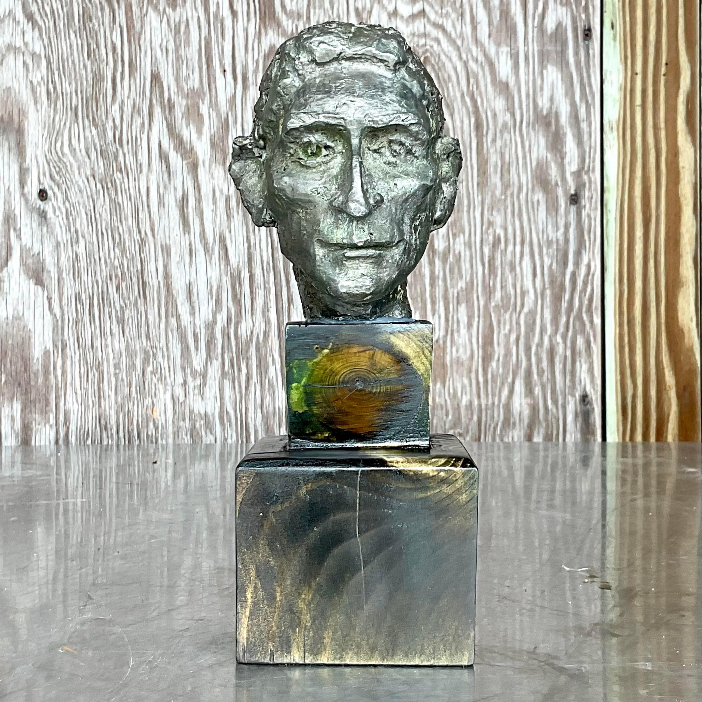 A fantastic vintage Boho sculpture of man. A chic patinated metal with lots of tactile detail. Rests on a double stack wood plinth with gorgeous grain detail. Acquired from a Palm Beach estate.