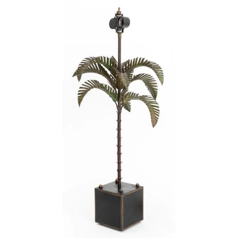 Lampada in metallo patinato a forma di piccola palma con foglie e tronco a fronde.  La lampada in stile tropicale poggia su una base a cubo con un terminale a sfera ad ogni angolo.  Il marchio parziale di Chapman testimonia i dettagli, la maestria e