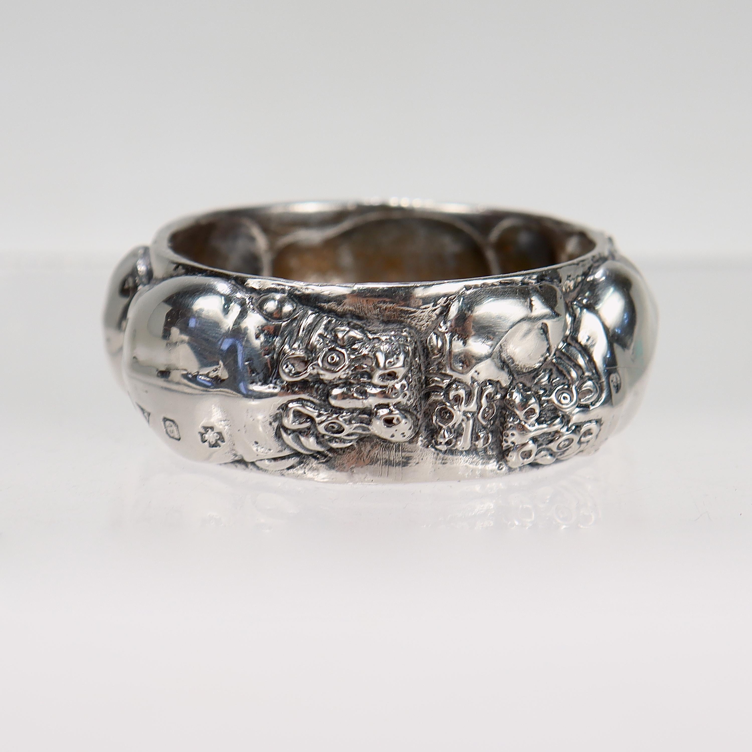 A fine Zimbabwean napkin ring.

In sterling silver.

By Patrick Mavros, the Zimbabwean luxury jewelry maker. 

With figural hippopotamuses around the circumference.

Simply a great Savannah-inspired silver napkin ring!

Date:
Late 20th or Early 21st