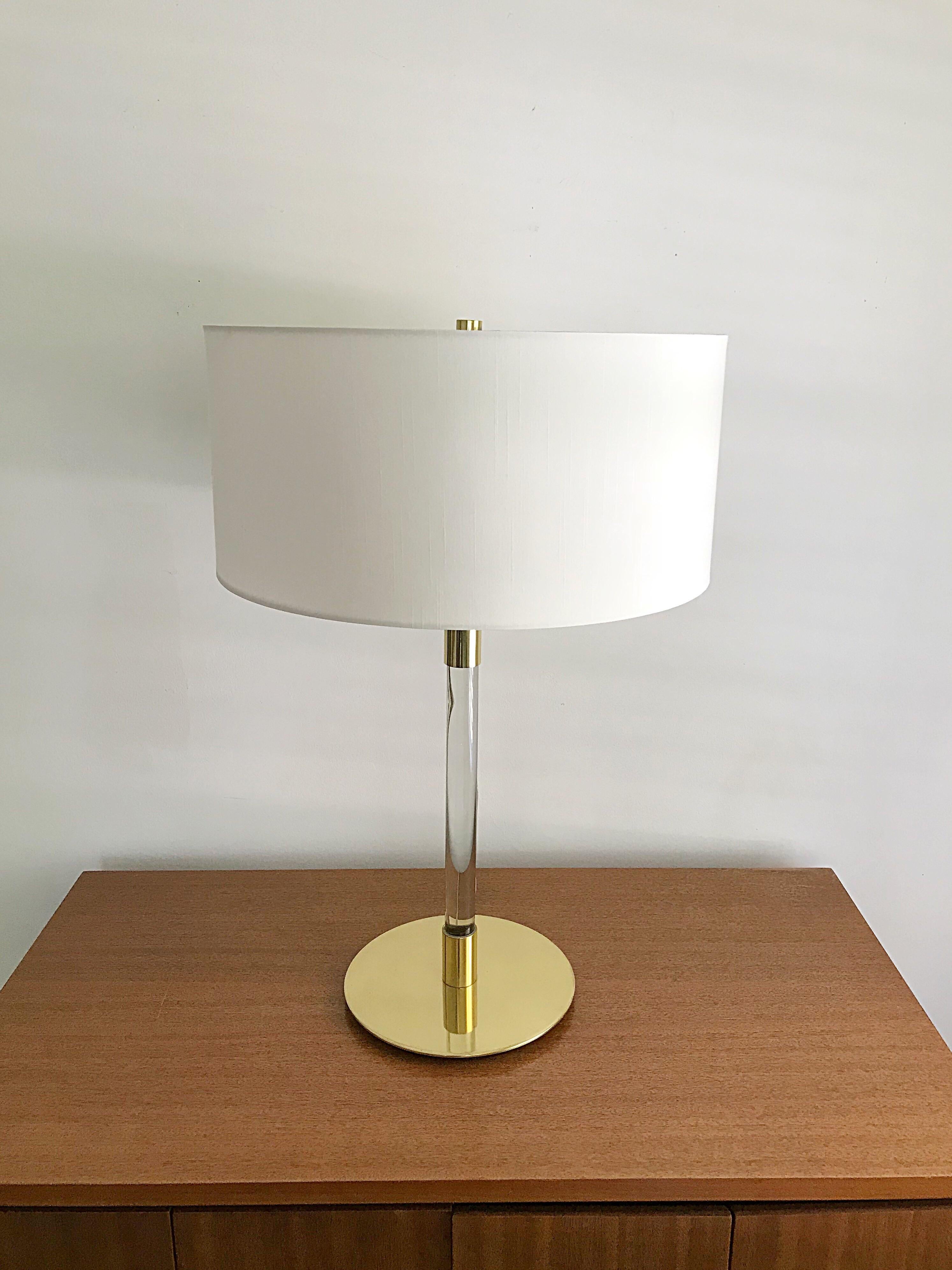 A brass lamp with a glass column by Hansen Lamps / New York. The lamp was manufactured by METALARTE and Made In Spain. There is a bulb switch and a switch on the cord which is all original and in very good condition. The lamp is designed such that