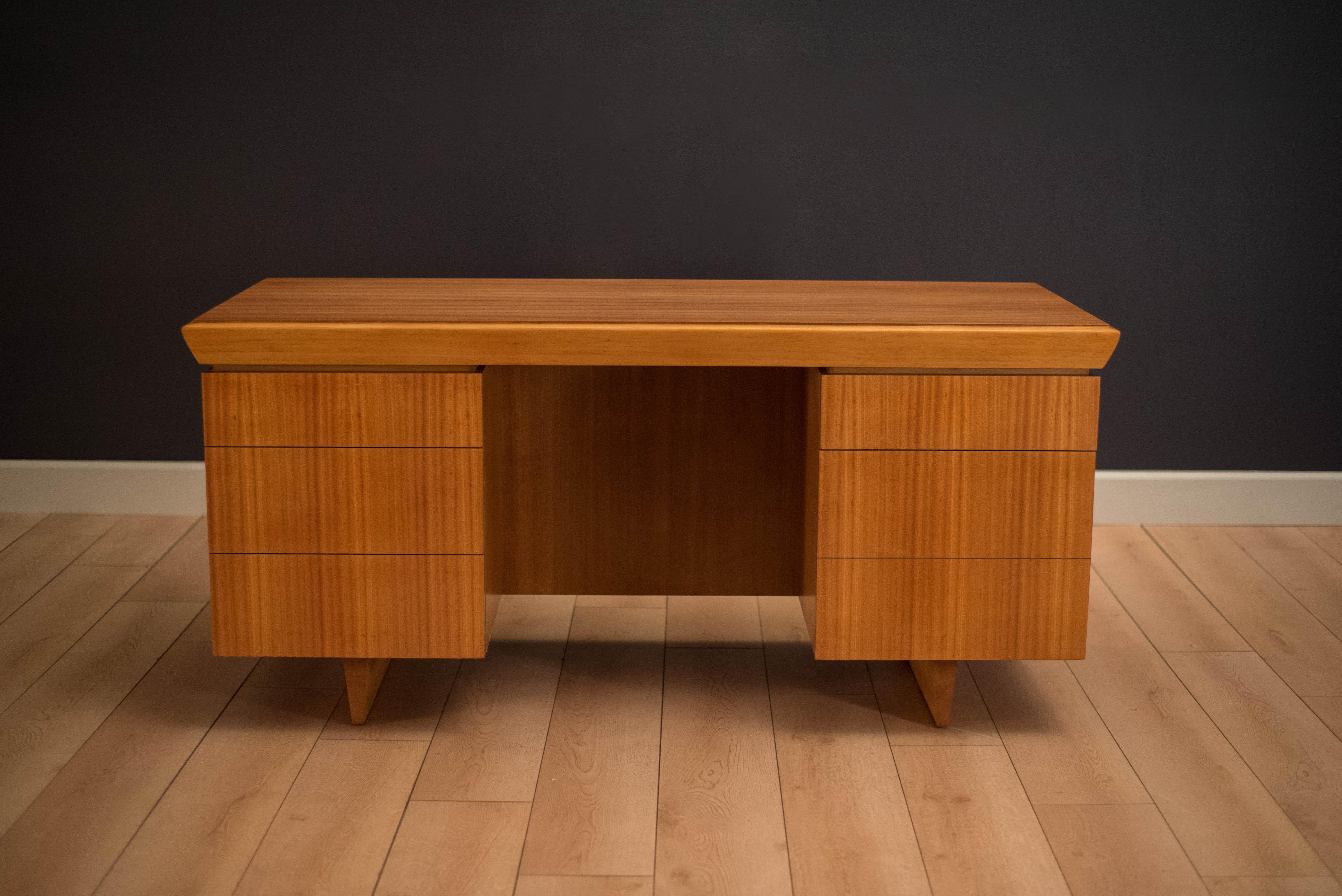 Mid-Century Modern desk designed by Paul Laszlo for Brown Saltman in mahogany. This piece can be displayed from any angle and includes a finished backside with a bookshelf display. Equipped with four storage drawers and one filing drawer.
