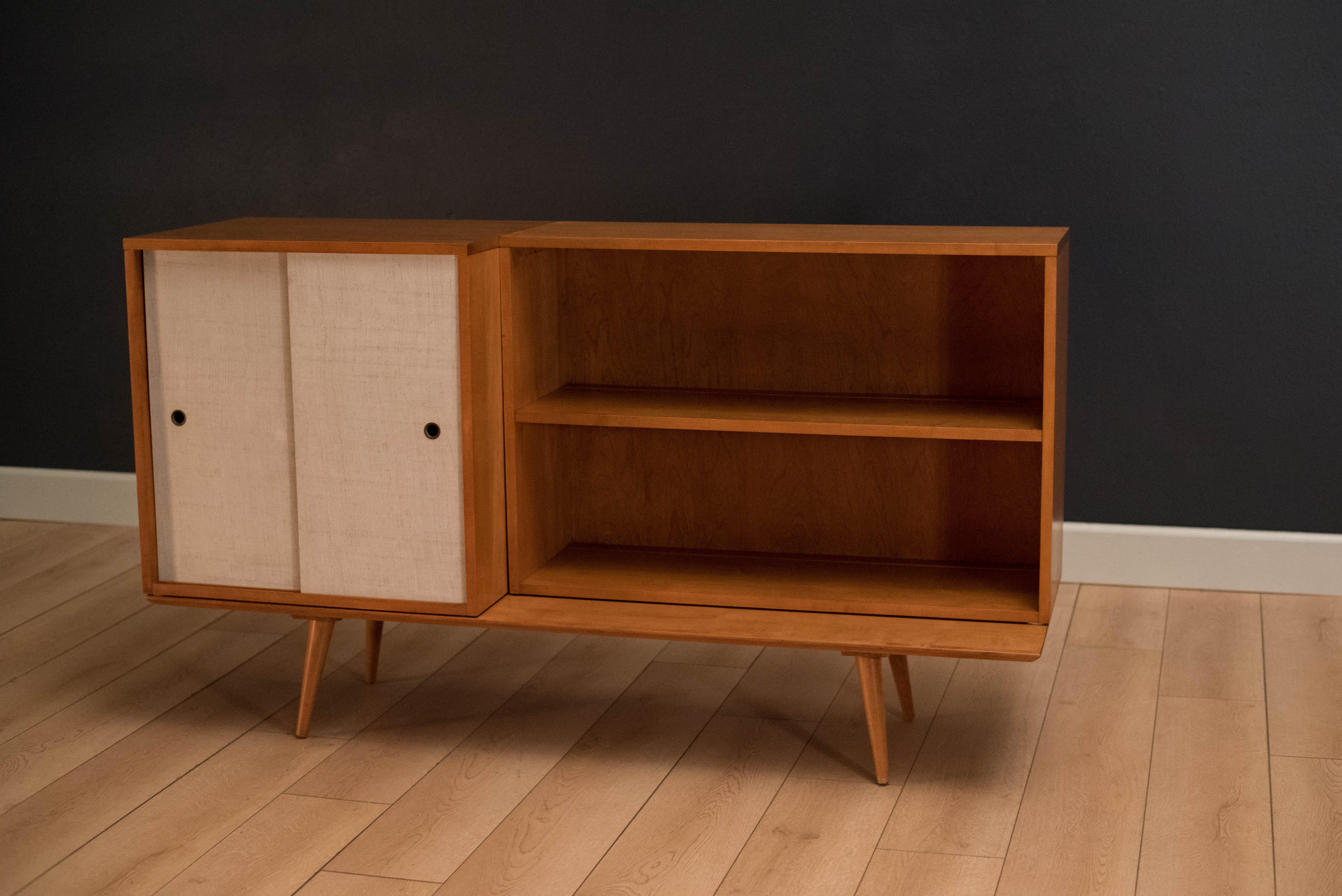 Mid Century Planner Group modular credenza by Paul McCobb for Winchendon Furniture. This set comes in three separate pieces and can be configured in any arrangement. Includes a fixed shelf cabinet with the original white grass cloth sliding doors,