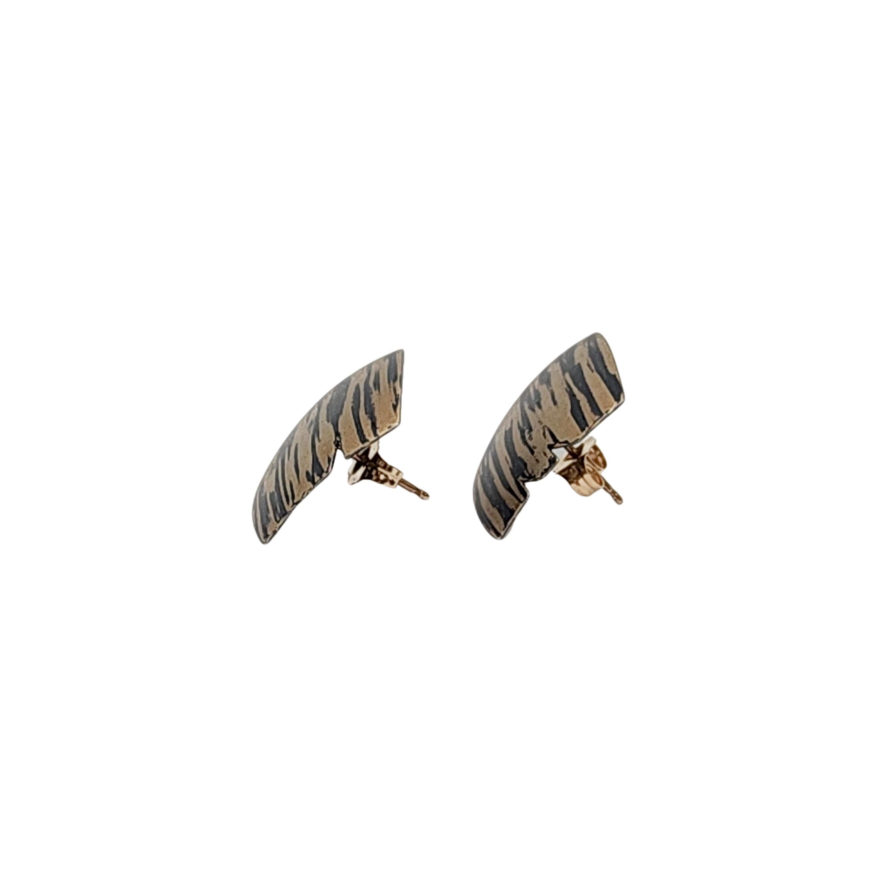 Sterling silver and 14K yellow gold tiger stripe square earrings by Paul Morelli.

Thin notched edge square earrings featuring 14K yellow gold with black sterling silver stripes.

Measures approx 5/8