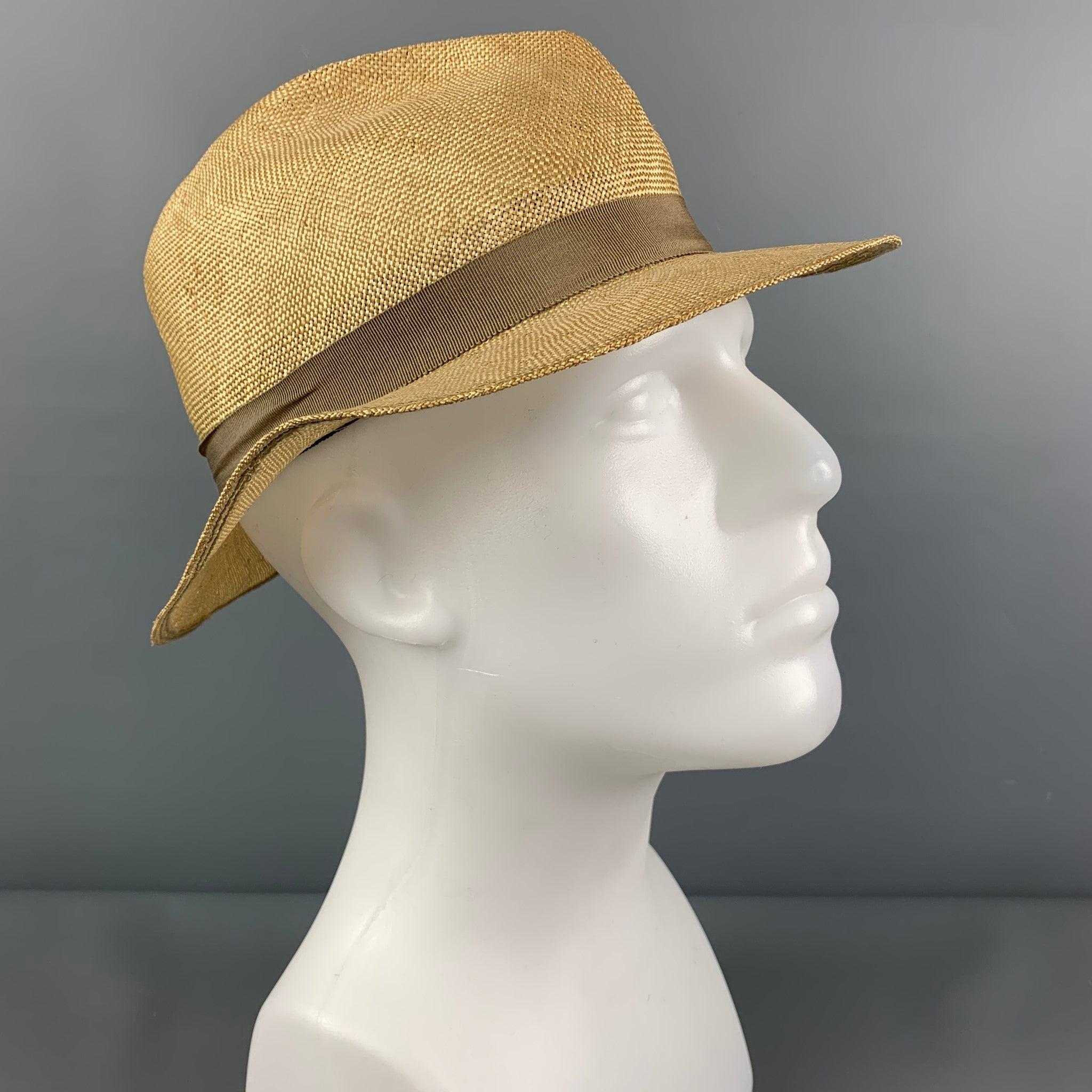 Vintage PAUL STUART hat comes in a beige straw featuring a fedora style and a tan ribbon trim.
Very Good
Pre-Owned Condition. Fabric tag removed.  

Marked:   Size tag removed  

Measurements: 
  Opening: 23 inches  Brim: 2 inches  Height: 4.5