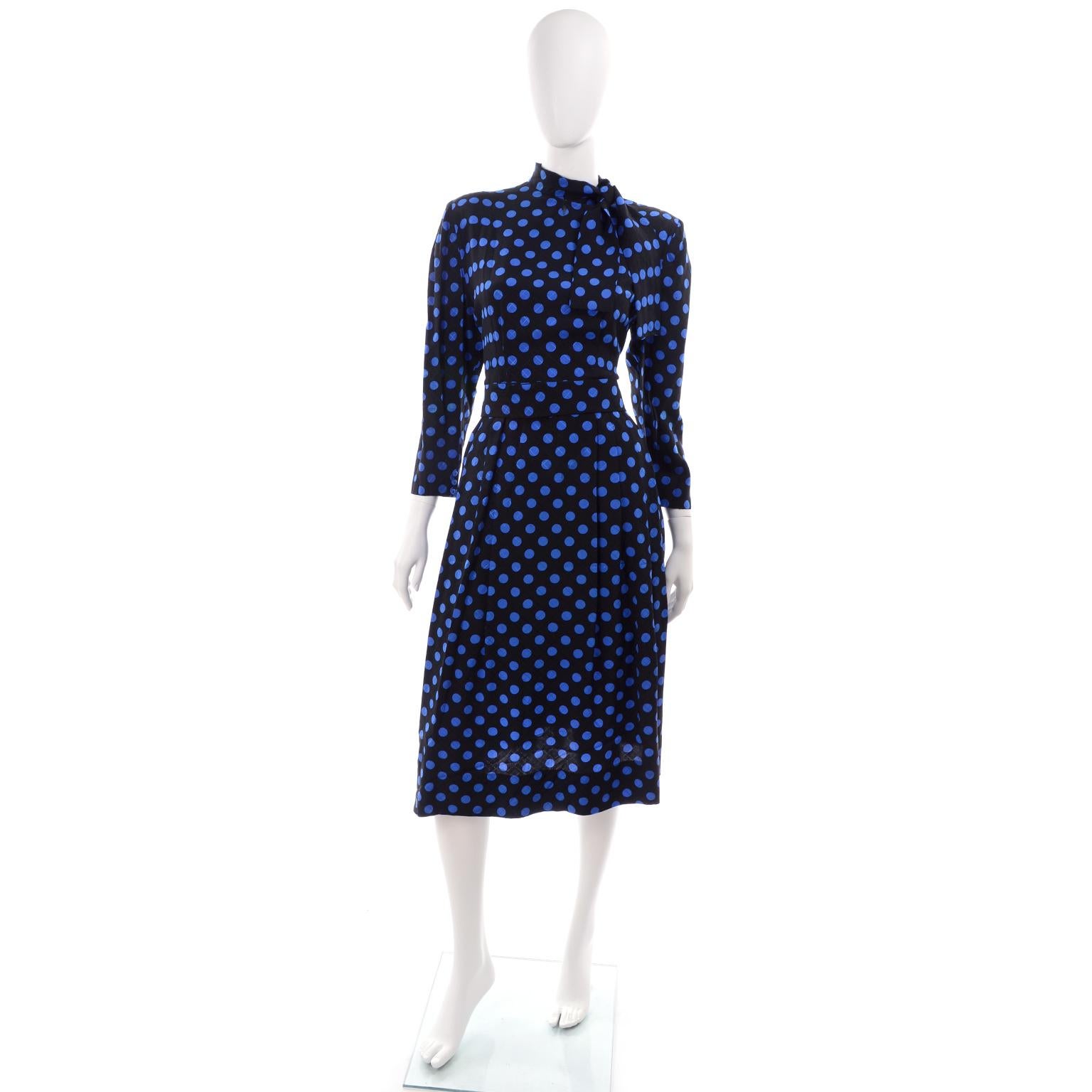 We adore Pauline Trigere vintage dresses and this one is really fantastic! The black window pane tonal patterned textured silk dress has electric blue polka dots throughout. This beautiful dress has a hand stitched hem, long sleeves, and a tie at