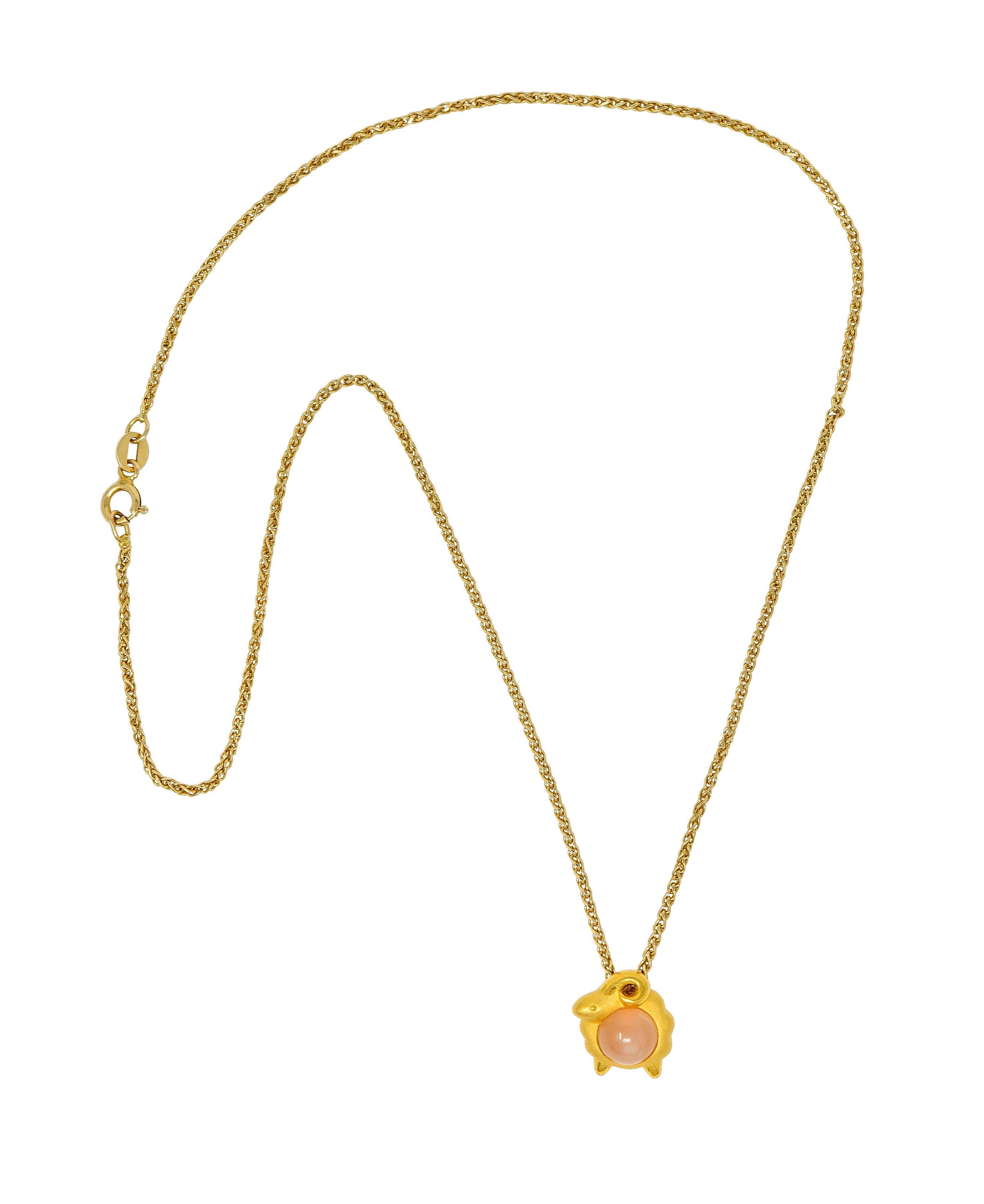 Faceted curb chain necklace suspends a stylized and cartoonish ram - representing the Aries zodiac

Ram centers a 7.0 mm round peach moonstone that exhibits moderate and white adularescence

Wool is matte gold while scrolled horns and feet are