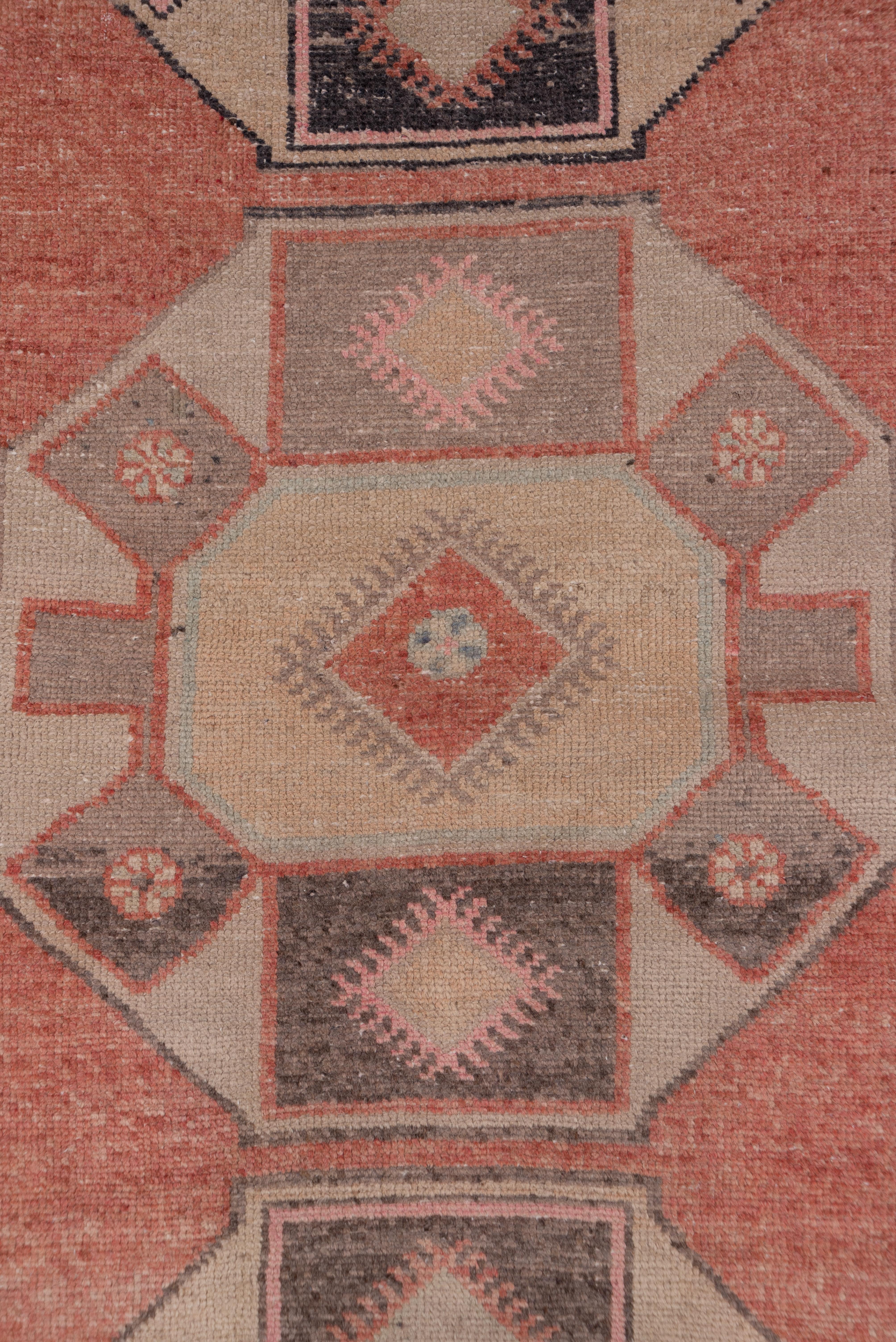 The peachy field displays five octagonal sand medallions with internal flapped octagons in straw, peach and abrashed light brown. The pattern is popular in eastern turkey with the Kurdish Yuruk nomads.