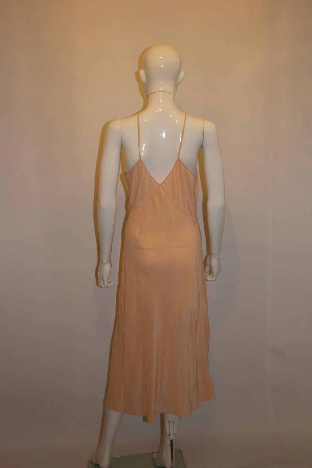 Une très jolie robe vintage rose pêche ou slip , idéal pour l'été. En soie très douce, elle présente un décolleté en V et de jolies découpes florales. Elle présente un joli dos et des bretelles spaghetti en soie.
Mesures : Buste jusqu'à 40'',