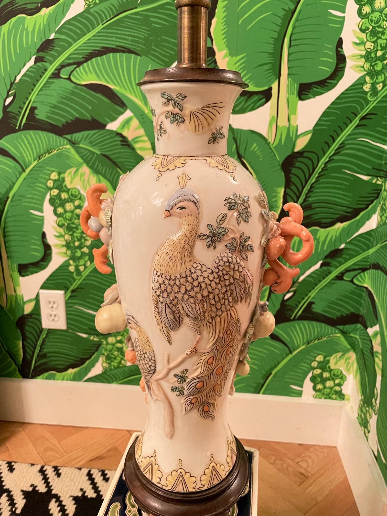 Vintage table lamp by Maitland Smith features a glazed ceramic body and wood pedestal. Adorned with peacocks and vines. Very good condition with only very minor imperfections consistent with age. May exhibit scuffs, marks, or wear, see photos for