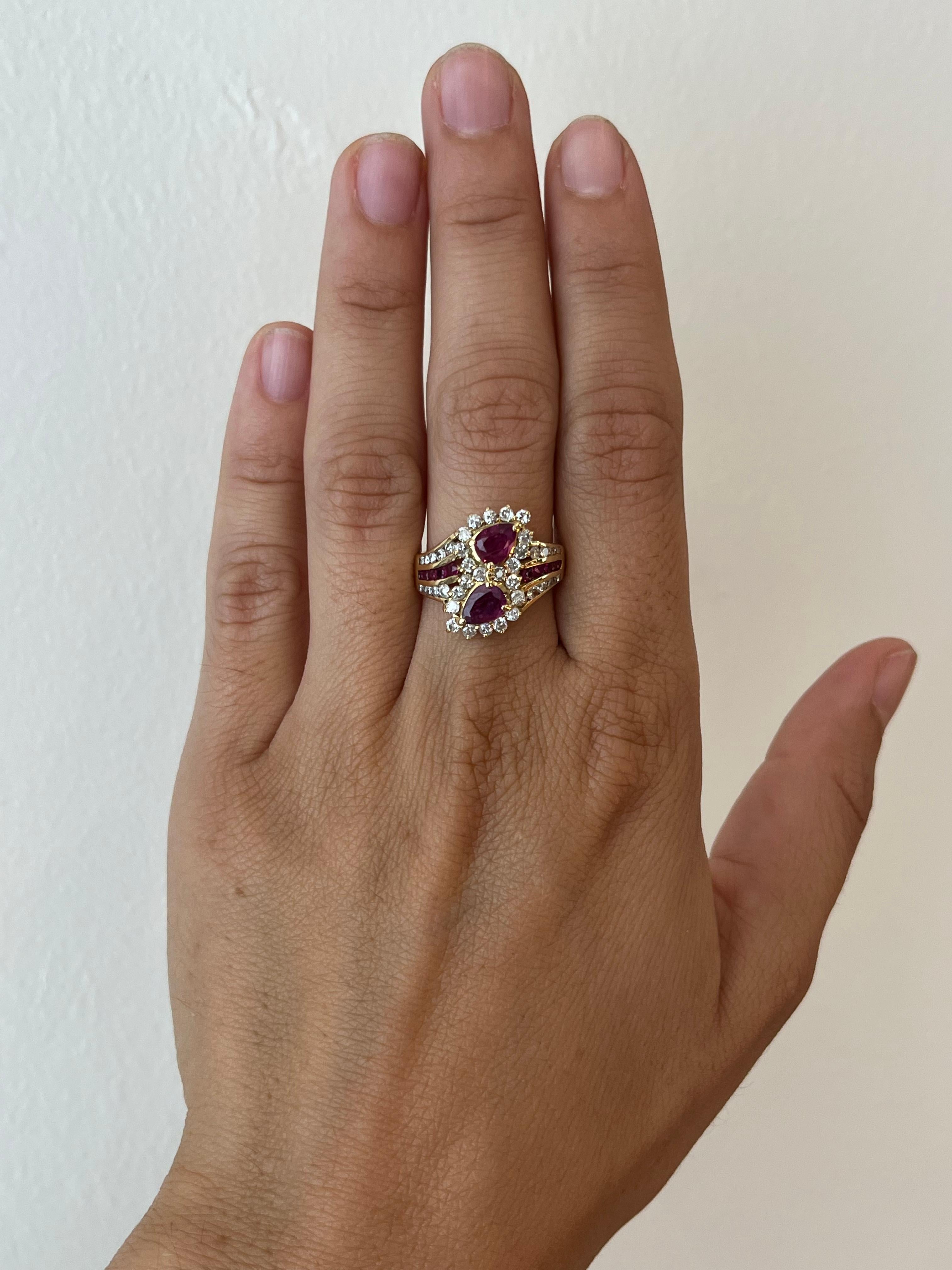 Zwei birnenförmige Rubine in einer Fassung aus 14 Karat Gelbgold, umgeben von Diamanten. Das spitz zulaufende Band ist mit weiteren Rubinen und Diamanten besetzt, die für ein farbenfrohes und funkelndes Schauspiel an den Seiten sorgen.

- 2