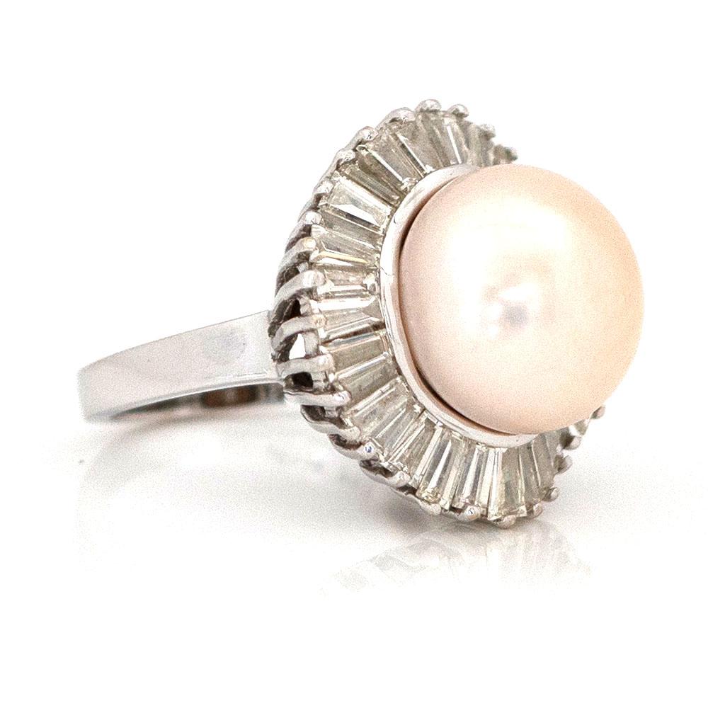 Discover the elegance of our 18ct white gold ring, showcasing a lustrous white pearl surrounded by 32 baguette diamonds in a captivating floating ballerina setting. In the Victorian era, this piece embodies symbols of innocence, purity, humility,