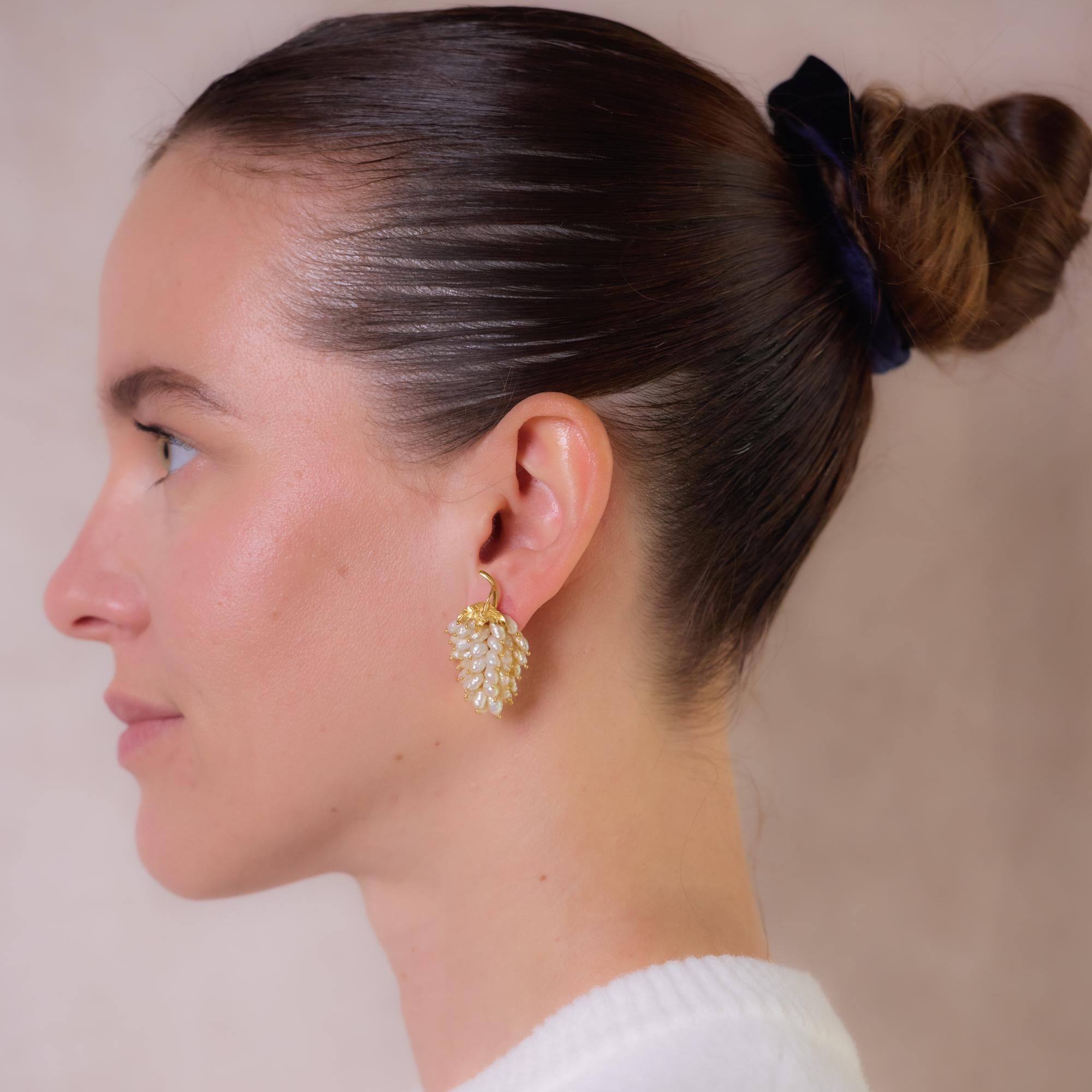 These vintage 18k yellow gold grape leaf earrings feature lustrous freshwater river pearls ranging from approximately 6.70mm to 5.60mm. Their nature-inspired design showcases timeless elegance and fine craftsmanship. Hallmarked with an 18k purity