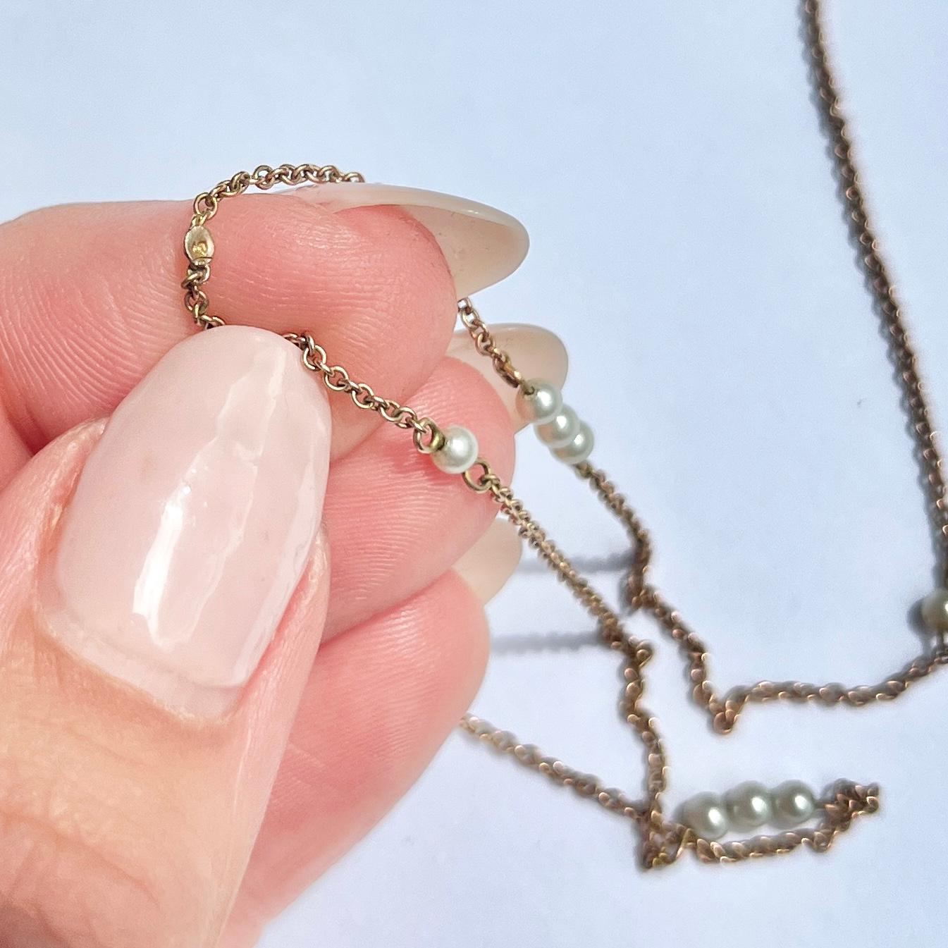 Ce collier très délicat est composé d'une fine chaîne en or 9 carats et contient des trios et des perles simples. Il n'y a pas de fermoir, mais il est suffisamment long pour être porté sur la tête. 

Longueur : 89 cm
Diamètre de la perle : 2