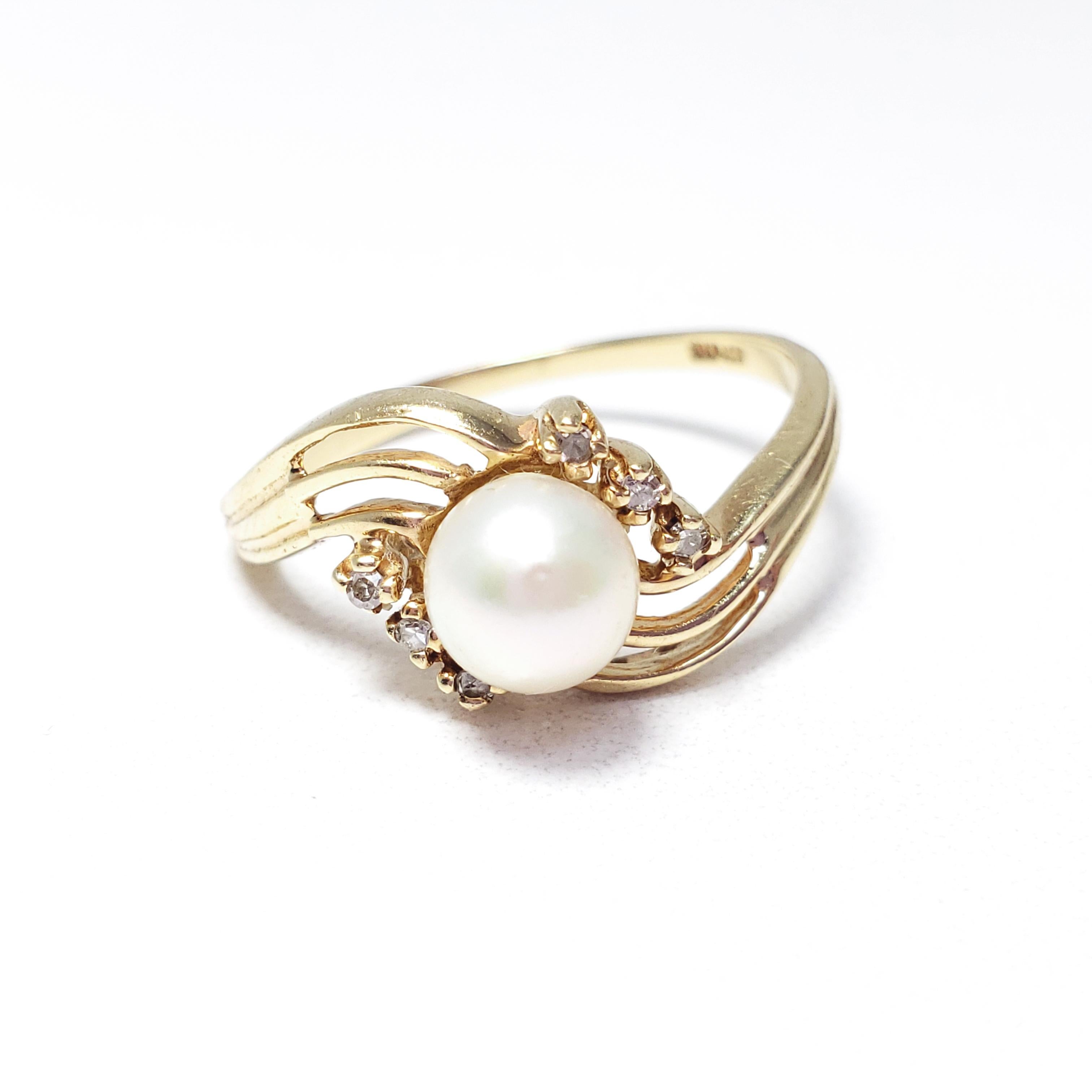 A classy vintage ring with a natural pearl centerpiece, 5.7 mm in diameter, accented with 6 diamonds. Set in a beautifully curved 10K gold band.

Hallmarks: 10KP, CTR

This ring is hallmarked 10KP, which signifies 10K gold plumb. This means it is
