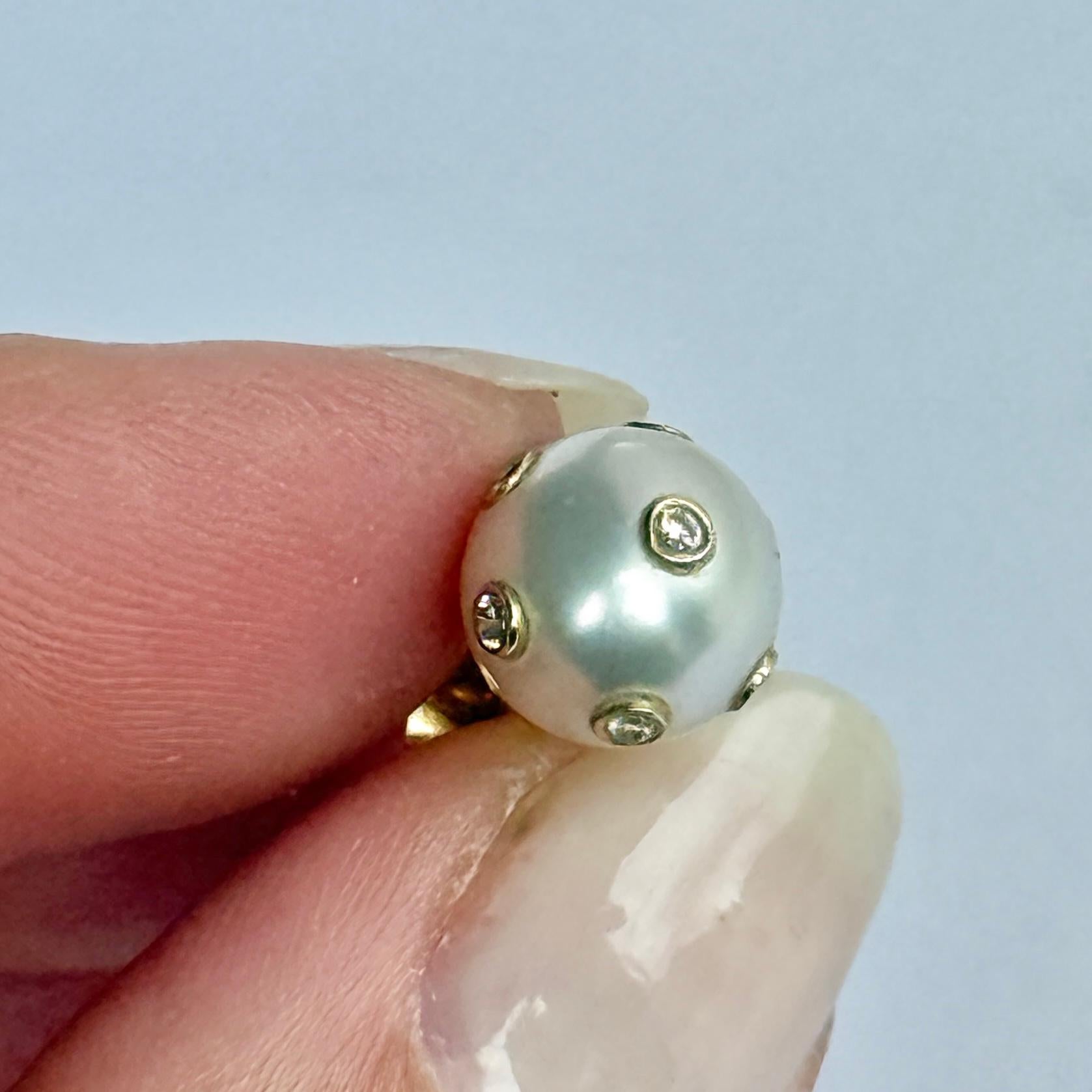 ¡El diseño de estos pendientes es impresionante! Las perlas grandes son  con diamantes engastados en oro de 18 quilates. Cada diamante mide 2pts y hay un total de siete en cada pendiente. 

Diámetro de la perla: 9 mm

Peso: 3.3 g