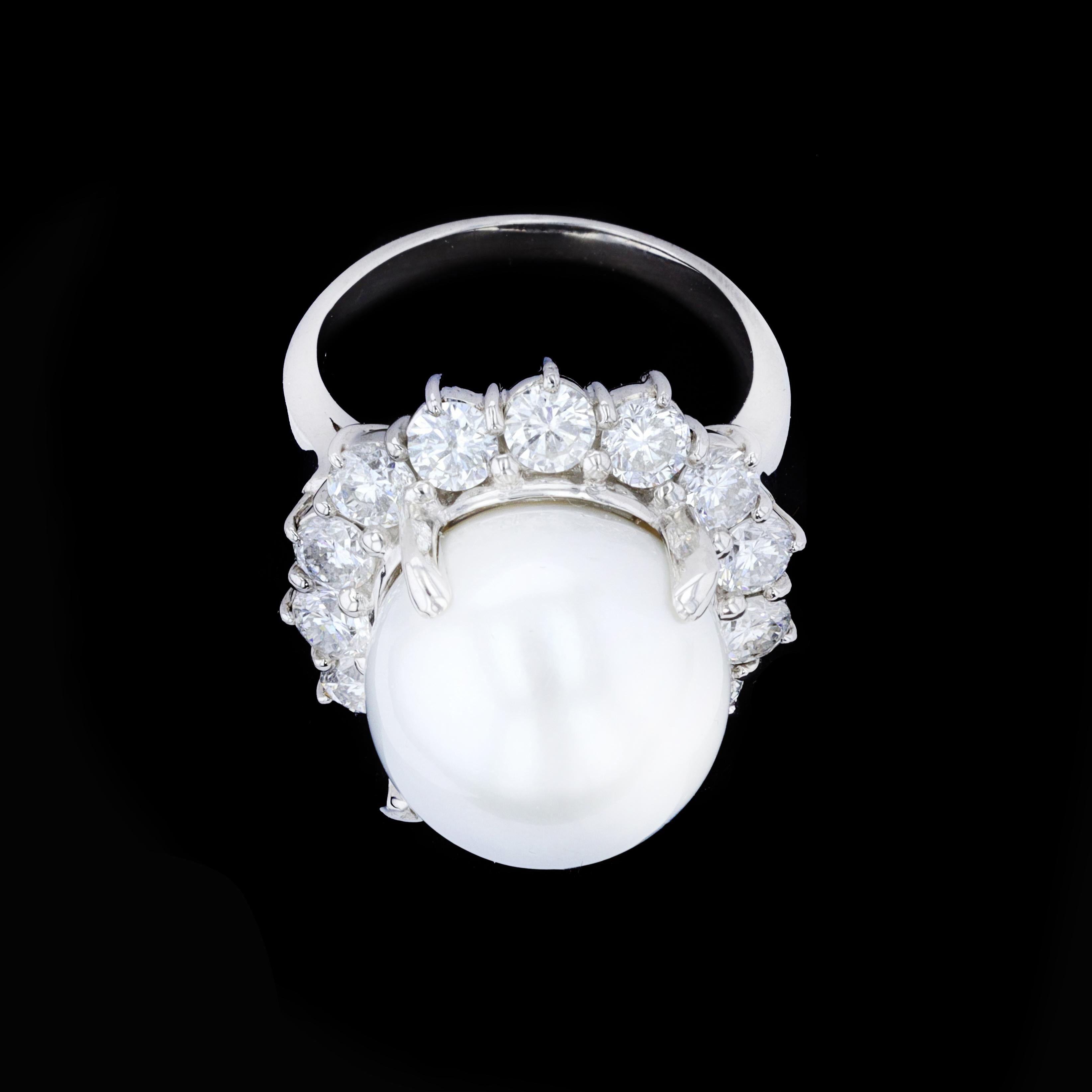 Dieser Cocktailring mit Perlen und Diamanten ist groß und gewagt und macht Spaß und hat Stil. Im Mittelpunkt steht eine runde Perle von 14,00 mm Durchmesser, umgeben von 14 runden Diamanten von 2,26 Ringen. Die Farbe dieser Diamanten ist F-G mit