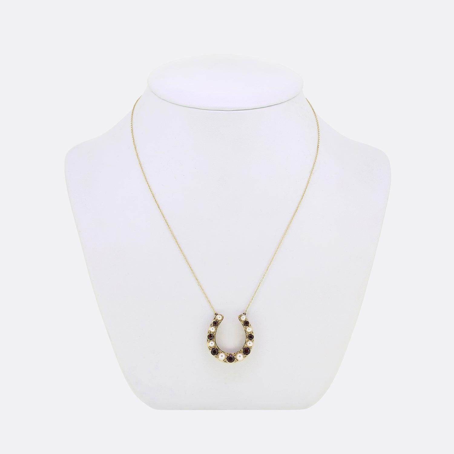 This is a lovely vintage lucky horseshoe necklace. The necklace features an alternating pattern of pearls and garnets in a 9ct yellow gold horseshoe motif. It started life as a Vintage brooch but has been transformed into a wonderful necklace by