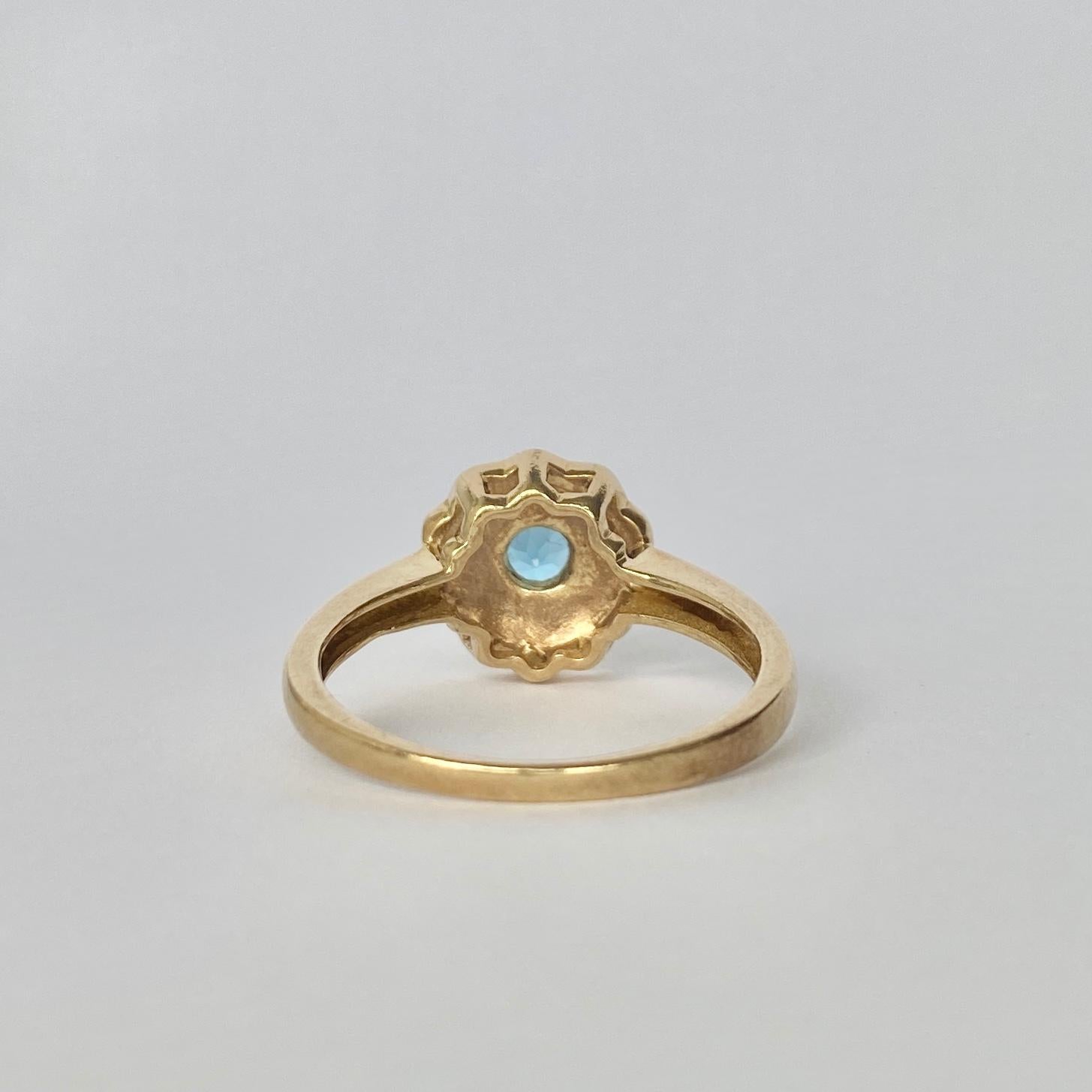 The blue of this topaz is bright and beautiful. It is complimented by the pale shimmer of the pearls surrounding it. The ring is modelled in 9ct gold. 

Ring Size: Q or 8 1/4 
Cluster Diameter: 10.5mm

Weight: 3.4g