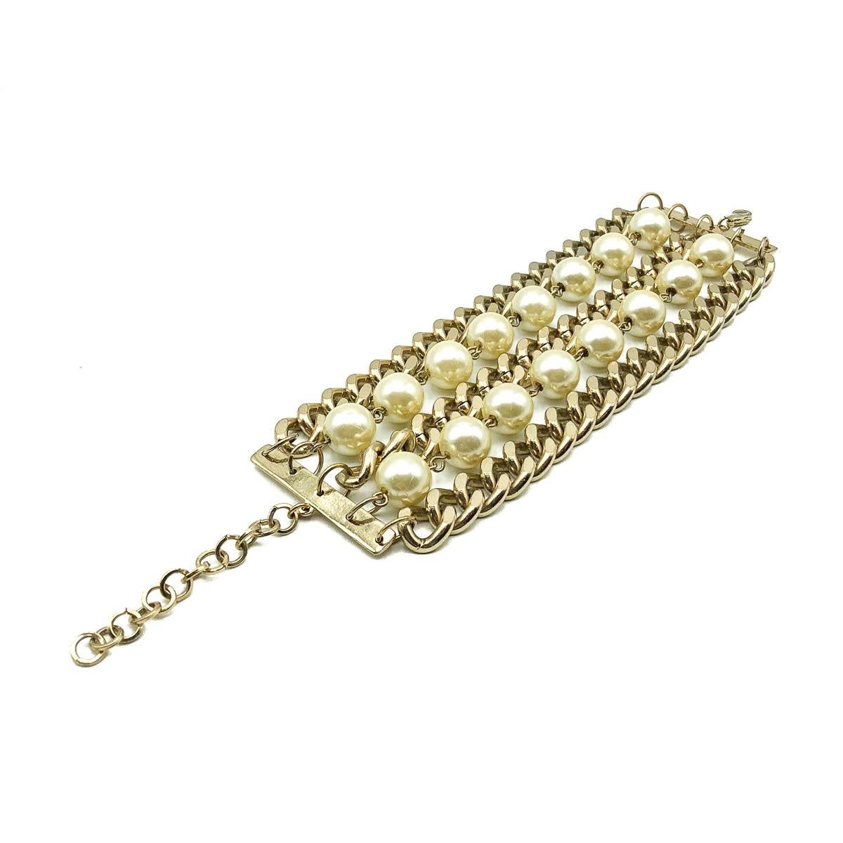 A Vintage Pearl Chainmail Cuff. Crafted in a light coloured gold tone metal with wonderful large glass faux pearl beads. Very good vintage condition, Adjustable 18-22cms. The striking combination of the flattened curb chains with the pearls creates