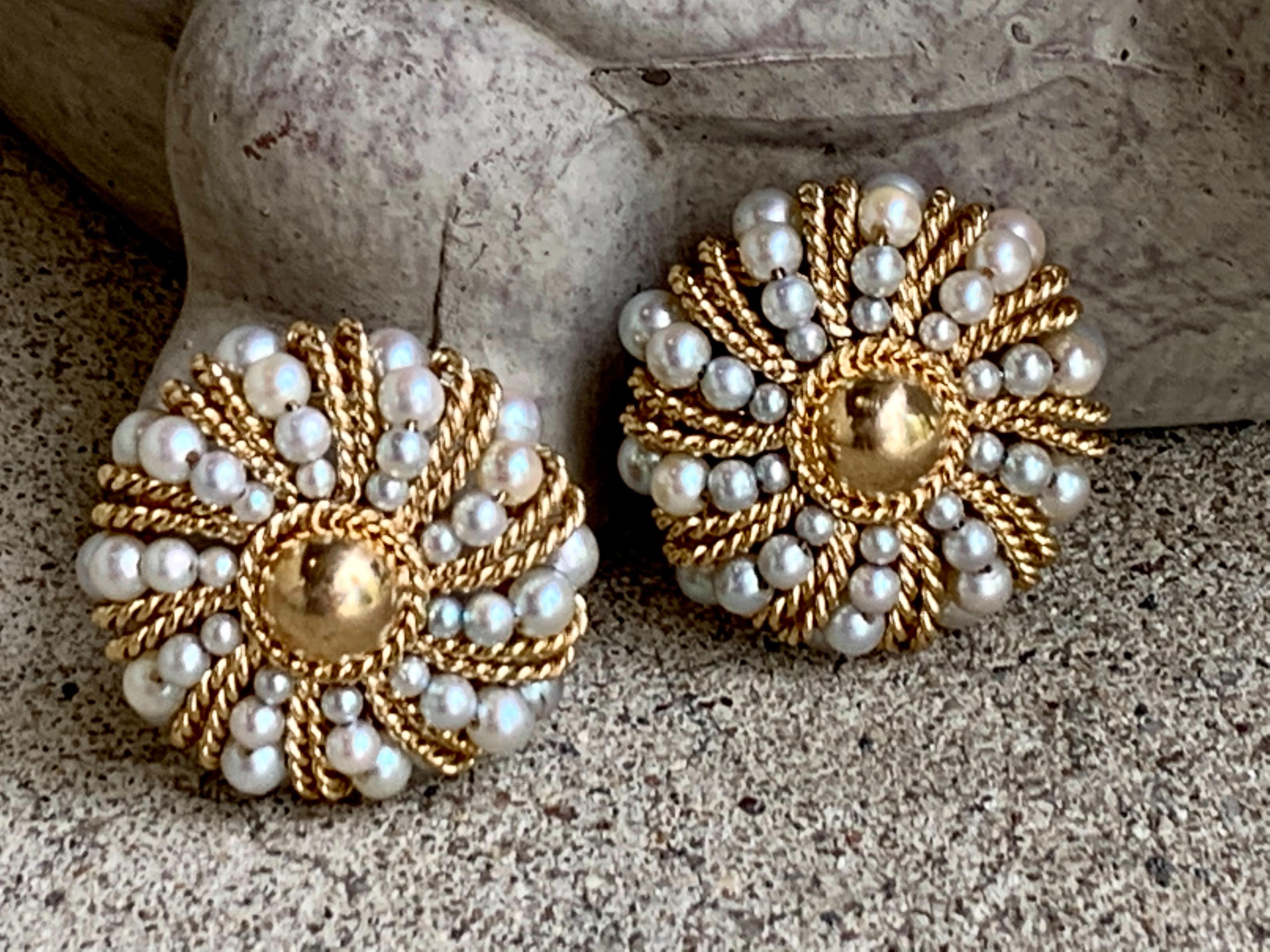 These stunning earrings feature 40 Pearls of various sizes, grouped together in a round cluster; they are strung together with 14 karat yellow Gold and feature 