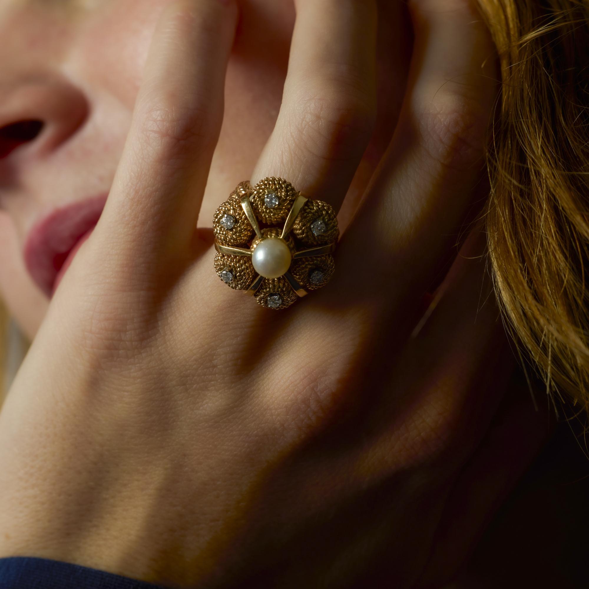 Este anillo vintage de oro amarillo de 14k muestra una perla luminosa abrazada por brillantes diamantes, que desprende elegancia atemporal y refinada artesanía.