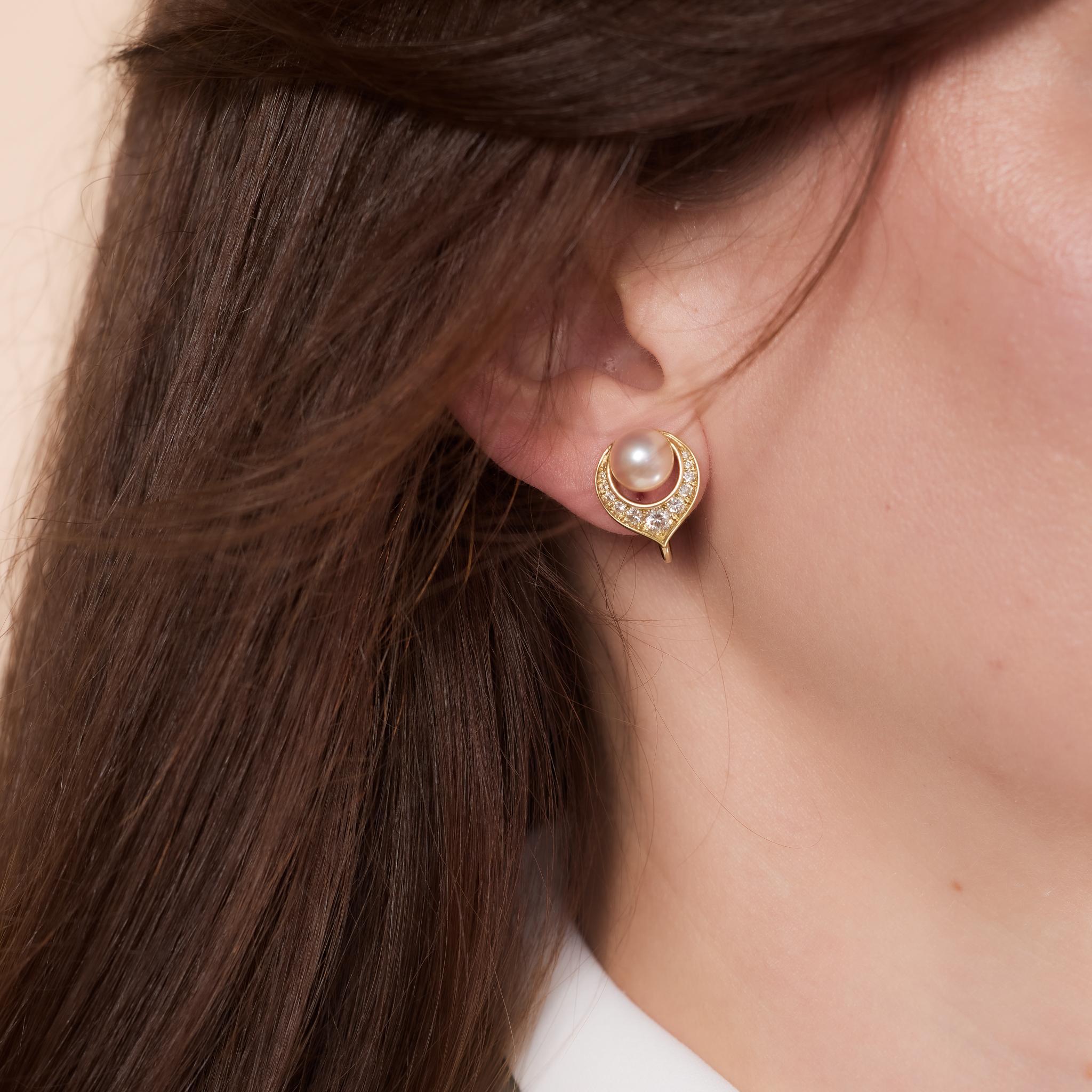 Vintage 18k yellow gold clip-on earrings with pearls and diamonds, circa 2000s.

Center stone: 2 pearls 
Size: Approximately 8.13mm-8.11mm
Accent stone: 22 round brilliant cut diamonds 
Weight: Approximately .65 carats
Color: D-E
Clarity: VS
Metal: