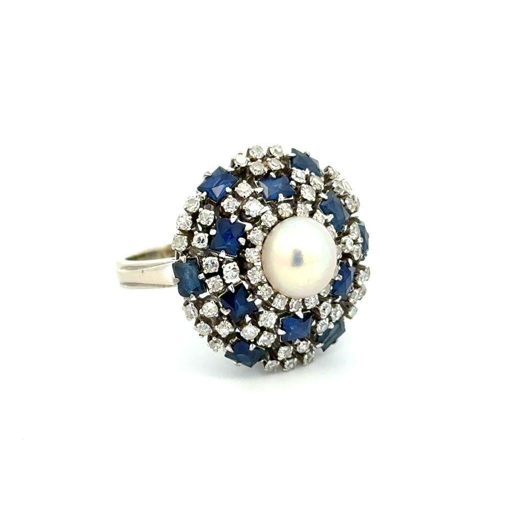 Sencillamente hermoso Anillo de cóctel Vintage Estate de oro con perlas, diamantes y zafiros finamente detallados. En el centro hay una Perla anidada con seguridad, rodeada artísticamente por Diamantes de 0,75 quilates y Zafiros Azules de 1,80