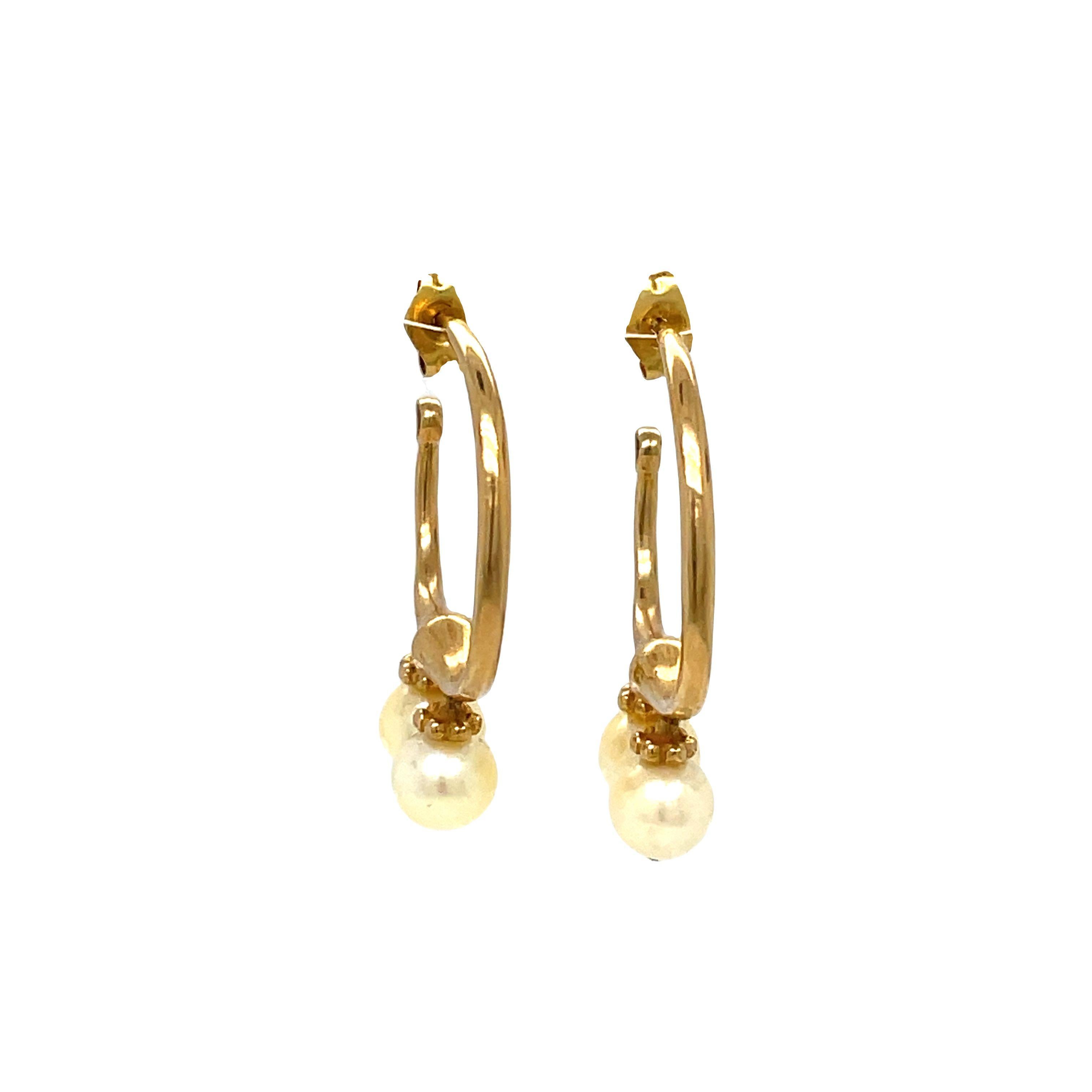 A double dose of chic. Look lovely and incandescent in these exquisite earrings. 

Two round freshwater cultured pearls dangle from a C Shape hoop. 5.5mm white drop cultured freshwater pearl 14k yellow gold dangle earrings.

They have push-on backs.