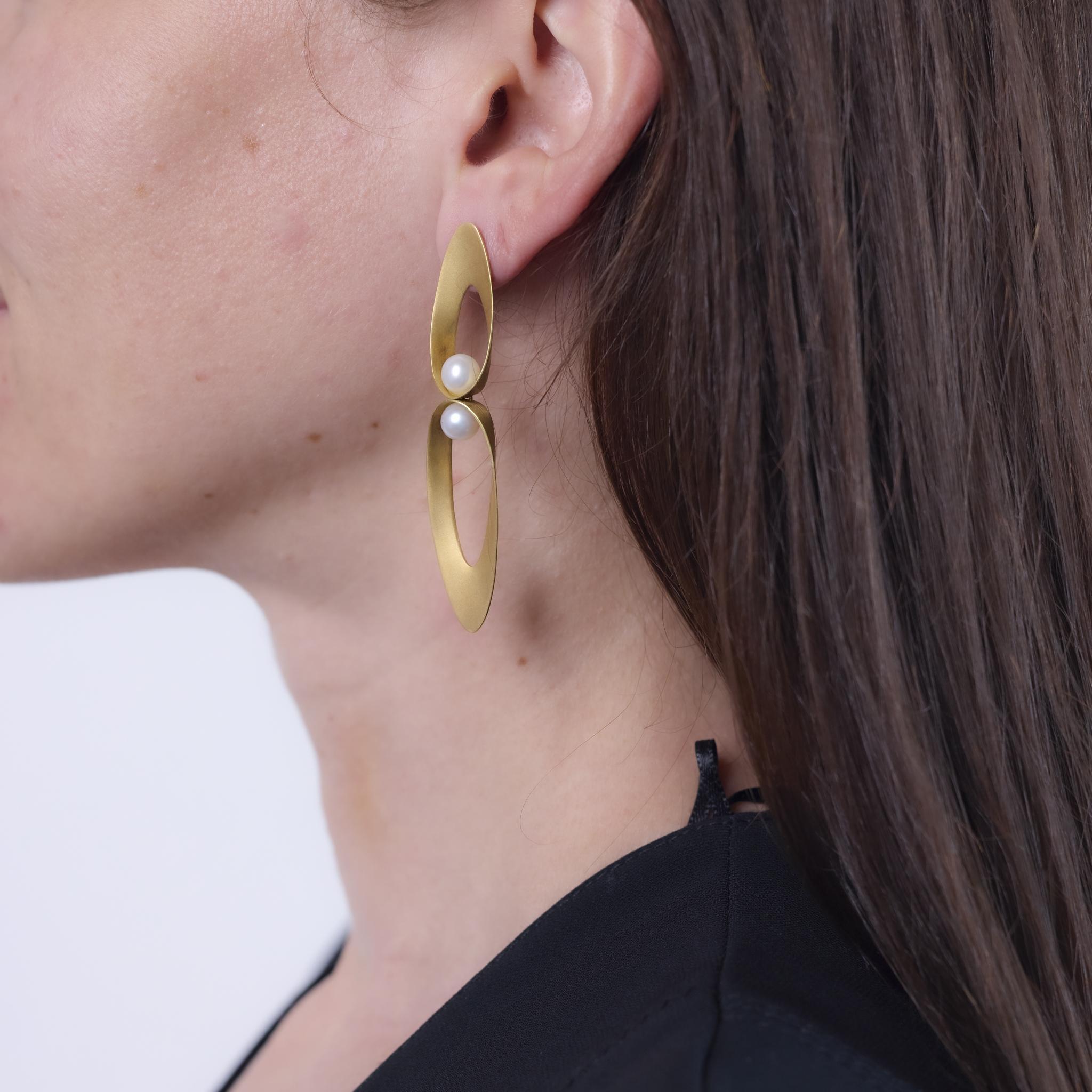 These vintage earrings from the 1970s are crafted in matte 18k yellow gold and feature four cultured pearls measuring approximately 6.46mm each. The elongated form and soft luster of the pearls offer a refined balance of texture and elegance.