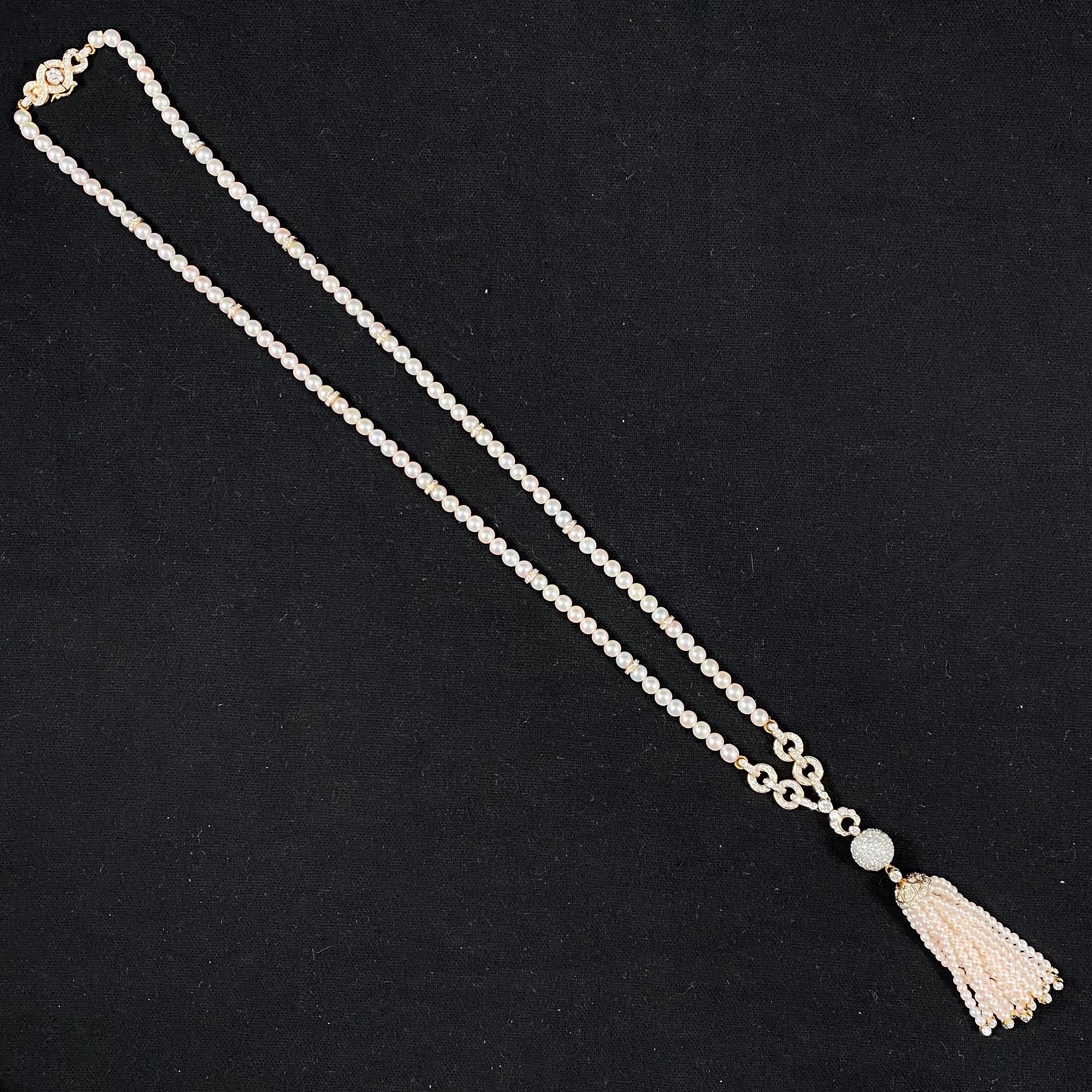 A vintage cultured pearl and round brilliant-cut diamond sautoir tassel necklace in 18kt yellow gold, 1970s. This Art Deco-style necklace is designed as a pearl strand on each side composed by spherical white pearls interspersed with diamond-set