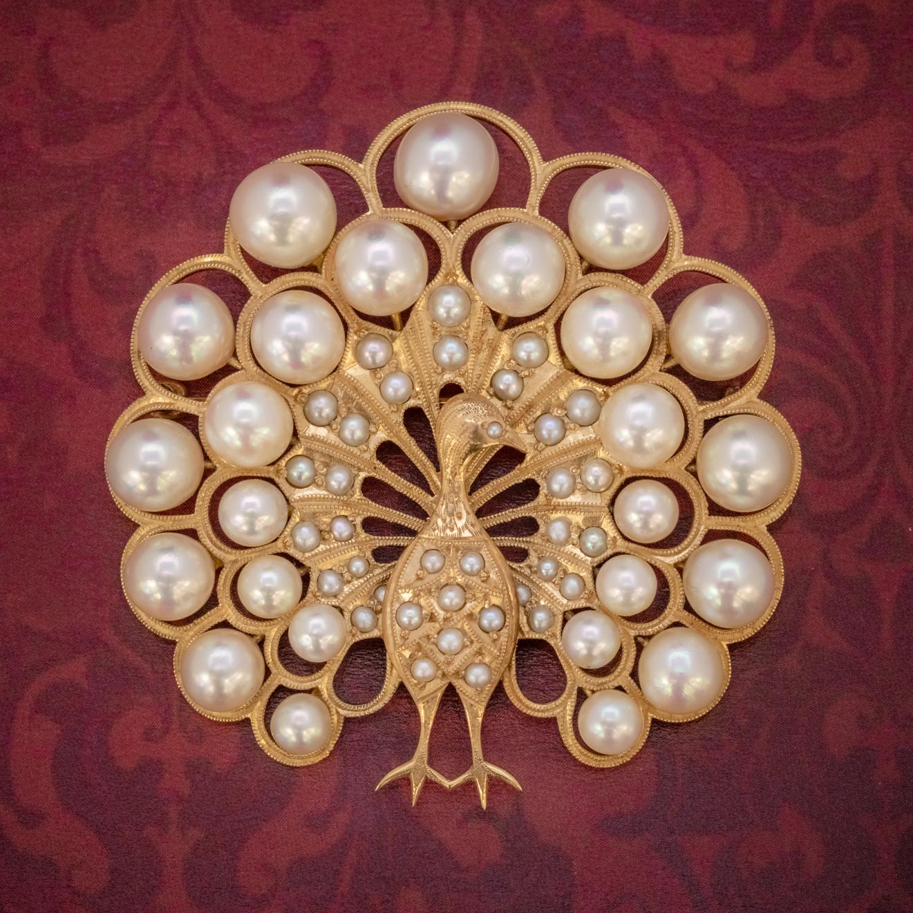 A majestic Vintage Peacock brooch decorated with an array of lustrous cultured Pearls of various sizes that graduate out from the body and across the peacock’s large and extravagant tail feathers. 

The piece is a wonderful open-worked design, with
