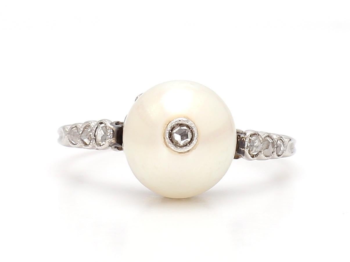 This elegant ring showcases a lustrous white pearl as its centerpiece. The pearl is accentuated by a series of white diamonds, each with a clarity of VS2 and a color grade of F, adding a subtle sparkle to the design.

Crafted by Iris Fine Jewelry in
