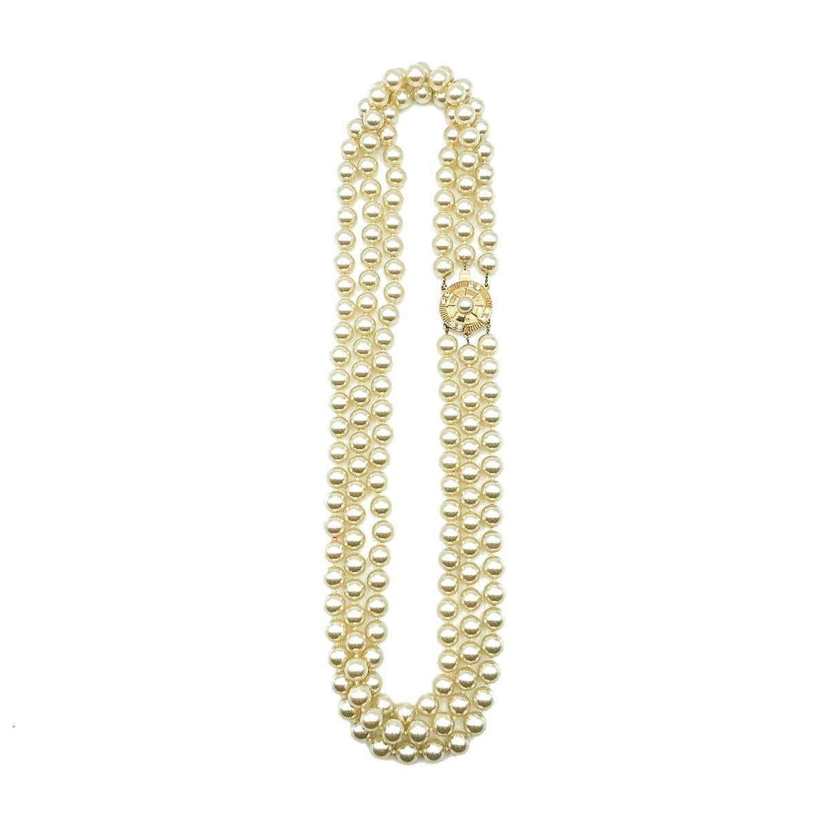 Eine dreifache Vintage-Perlenkette. Sie besteht aus drei wunderschönen Strängen aus nicht abgestuften Glasimitationsperlen und ist mit einem mit Kristallen und einer zentralen Perle verzierten Verschluss im Stil einer Zielscheibe versehen. Sehr