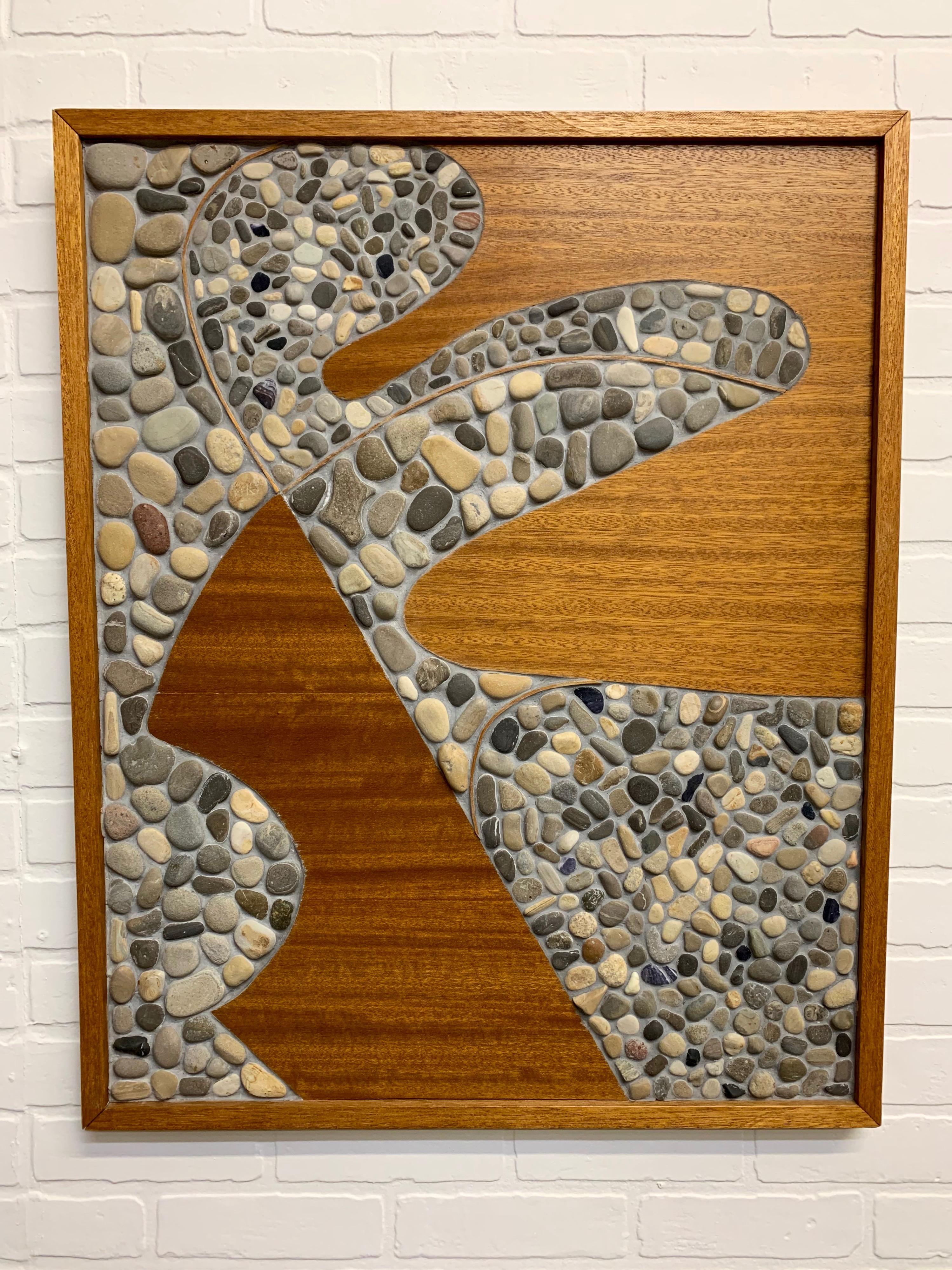 Abstract assemblage of stone mounted on board with wood surround.