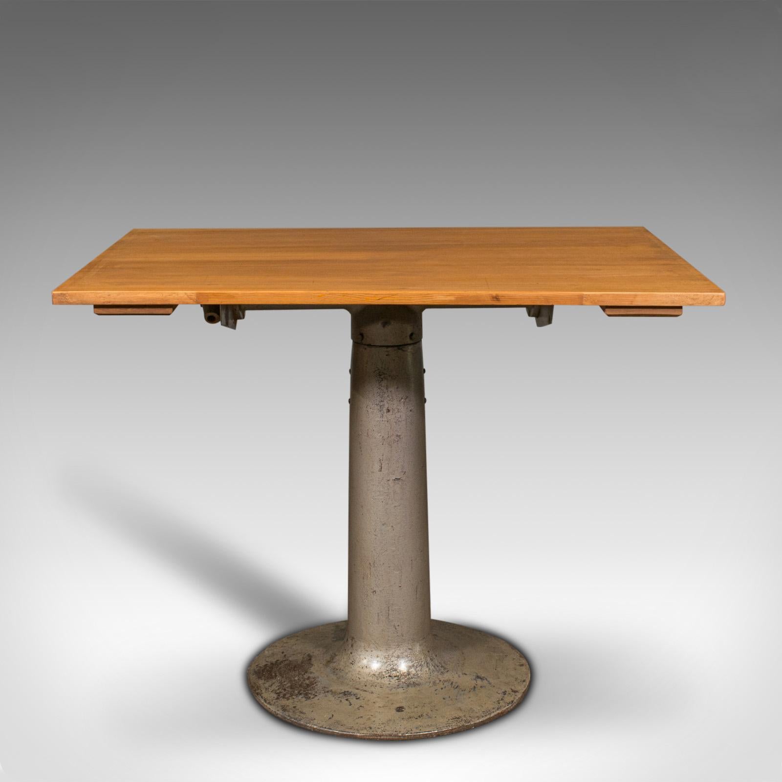 This is a vintage pedestal table. An English, beech and pine kitchen table or desk, dating to the mid 20th century, circa 1950.

Graced with an appealing mid century industrial aesthetic
Displays a desirable aged patina and in good order
Beech and