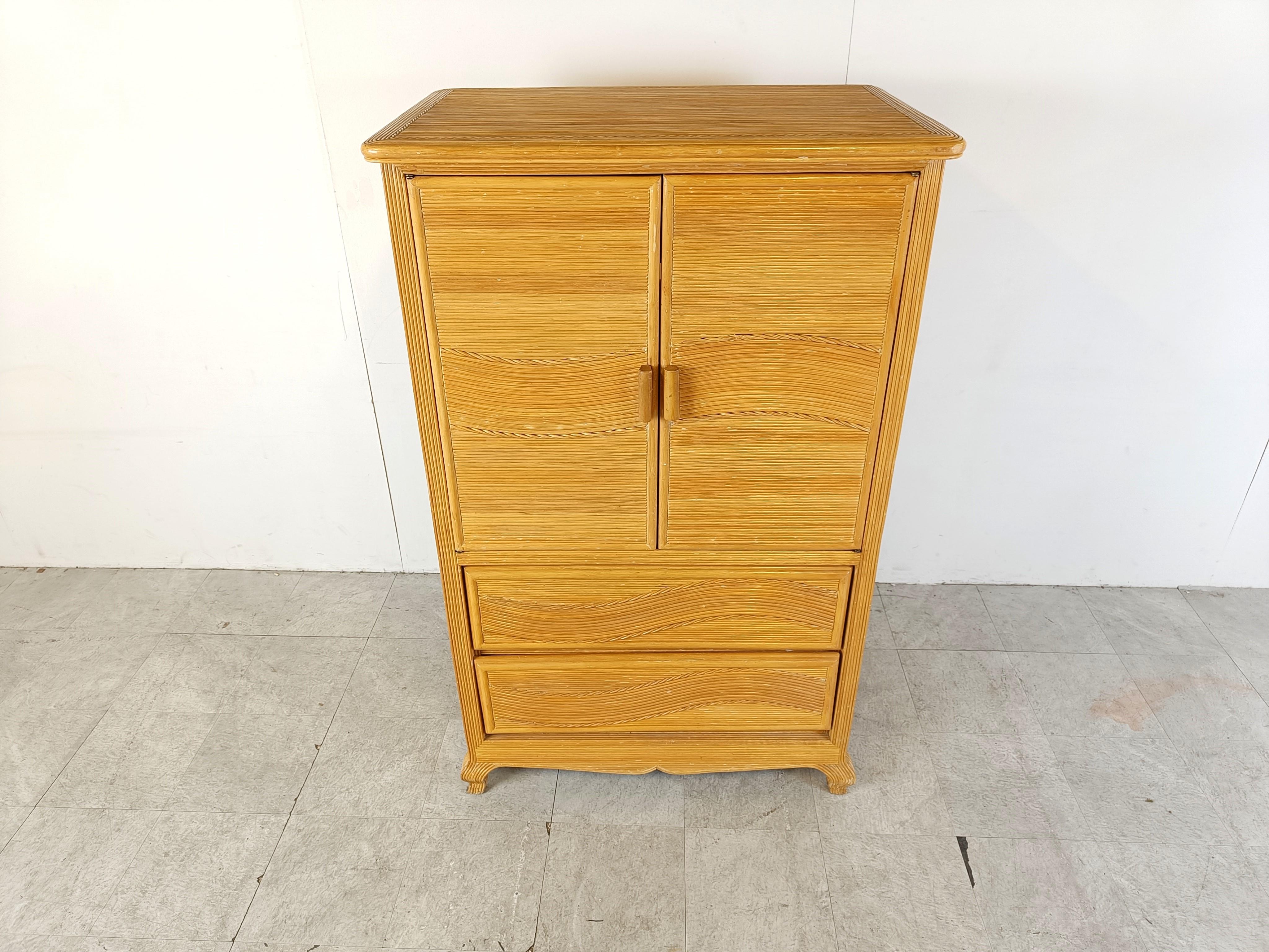 Elegant pencil reed cabinet with two doors and two drawers.

Very elegant curved legs and a nice reeded pattern running troughout.

Good condition.

1970s - France

Dimensions:
Lenght: 90cm/35.43