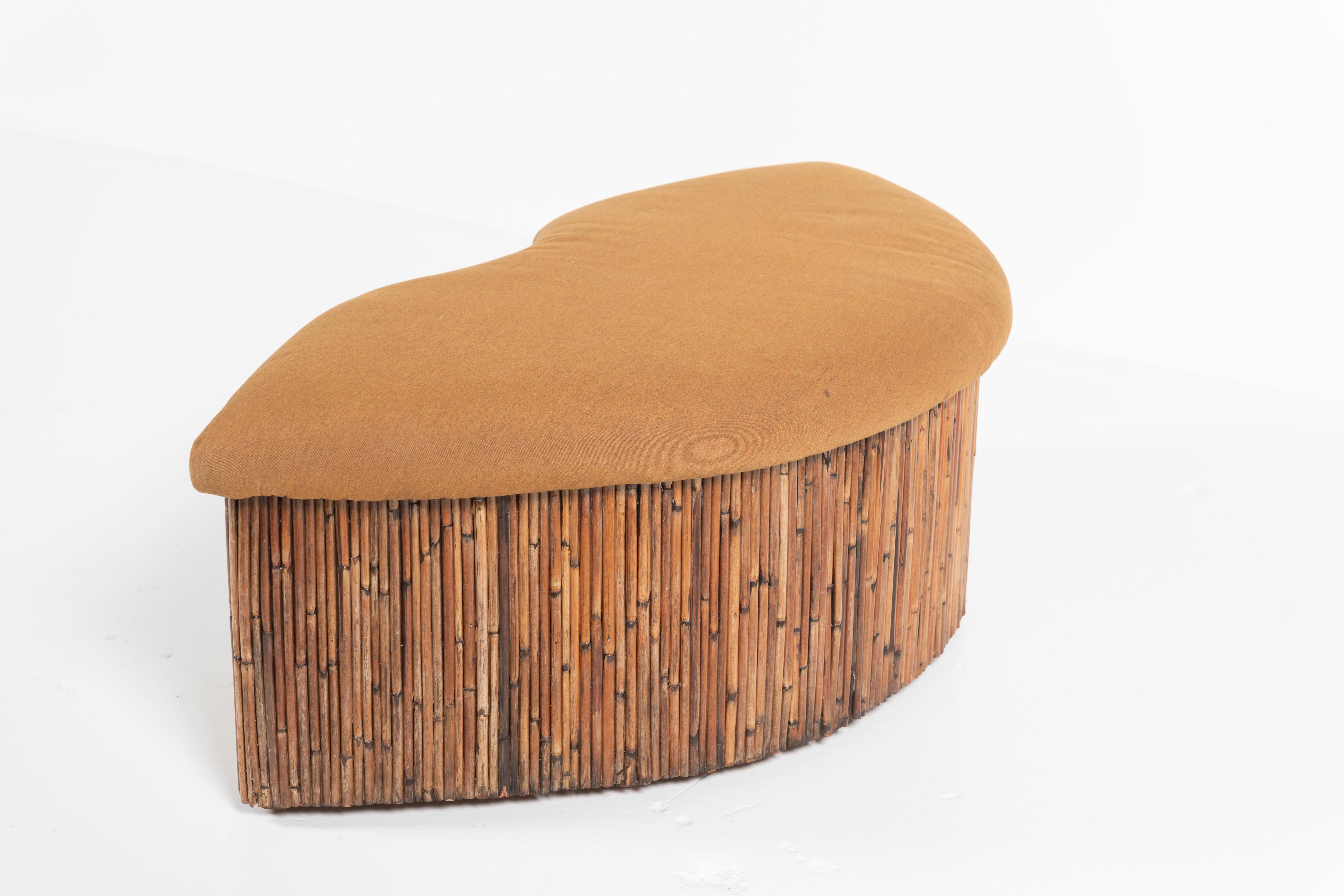 Mid-Century Modern curved bench made of pencil reed and covered in fabric. The piece is a mix of Hollywood Regency, Caribbean and Island design and brings a relaxed coastal charm to your room. Upholster in your favorite fabric and take a seat. The