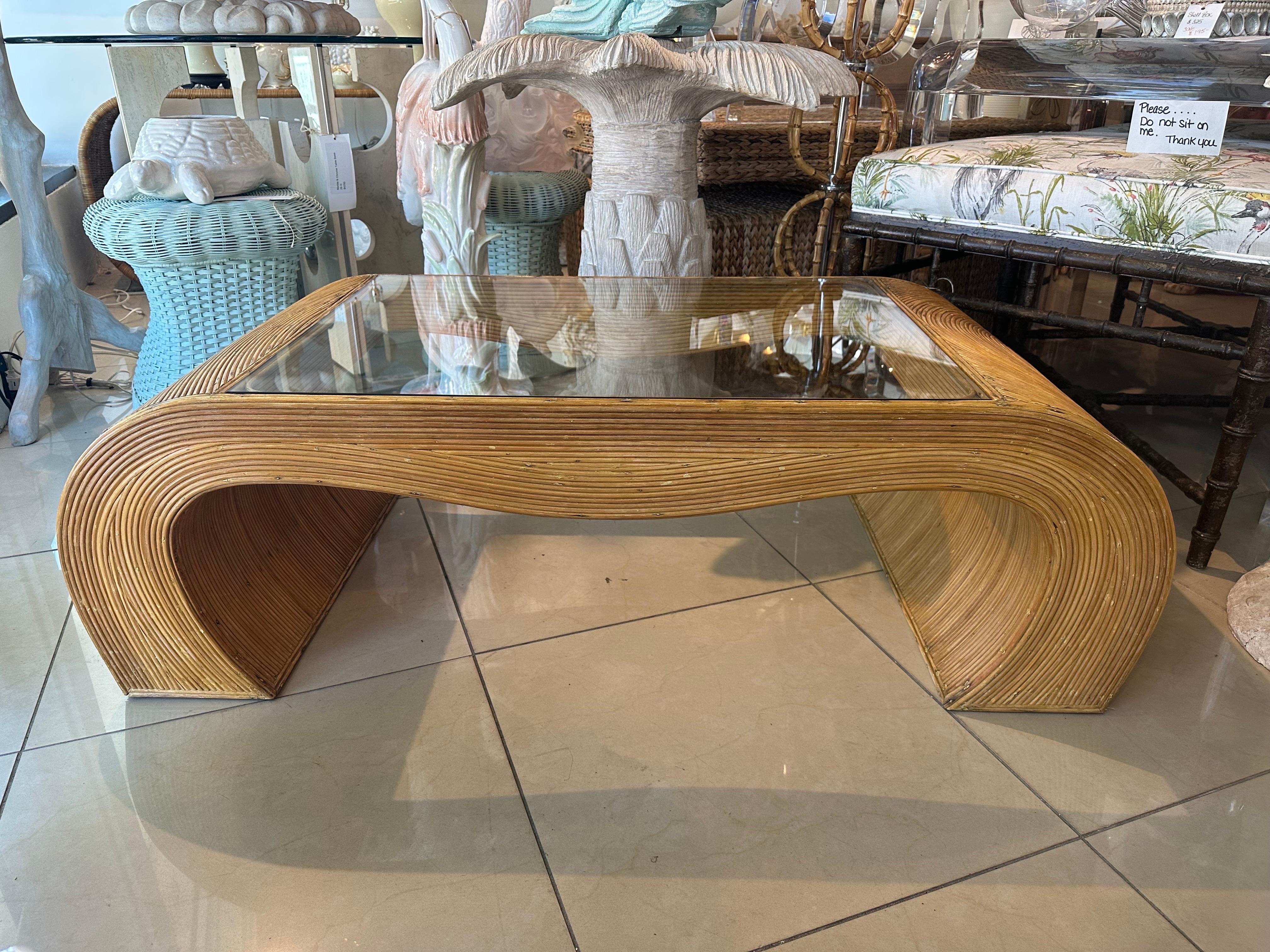Table de cocktail vintage en roseau et rotin. Un nouveau verre a été découpé pour la partie supérieure. Dimensions : 48 L x 24 D x 15 H.
