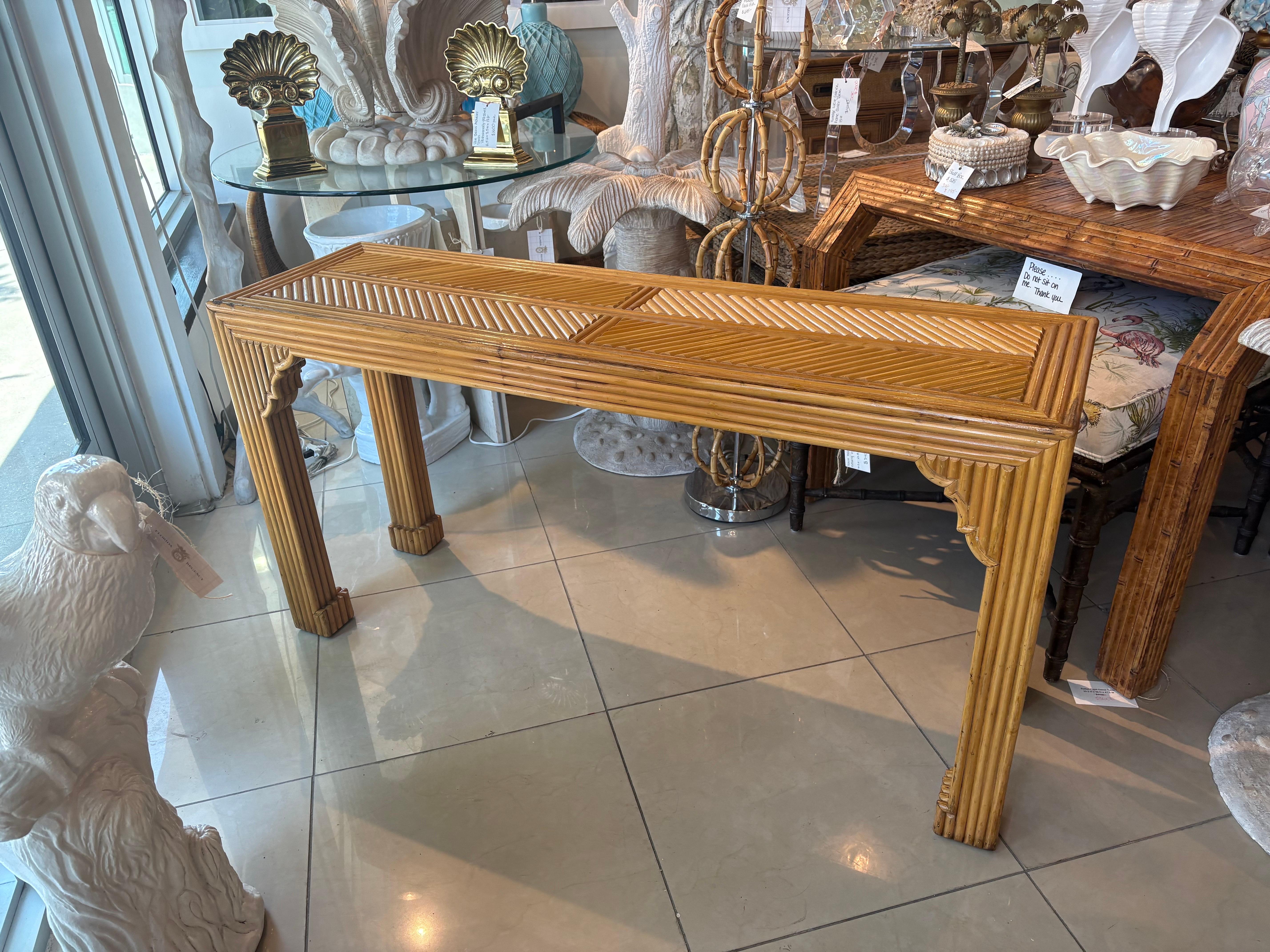 Beautiful vintage pencil reed rattan console table. Moroccan flare. Lovely details. This piece has been cleaned and polished. No damage or defects. Natural color variations to rattan. Dimensions: 27 H x 16 D x 53.5 L.