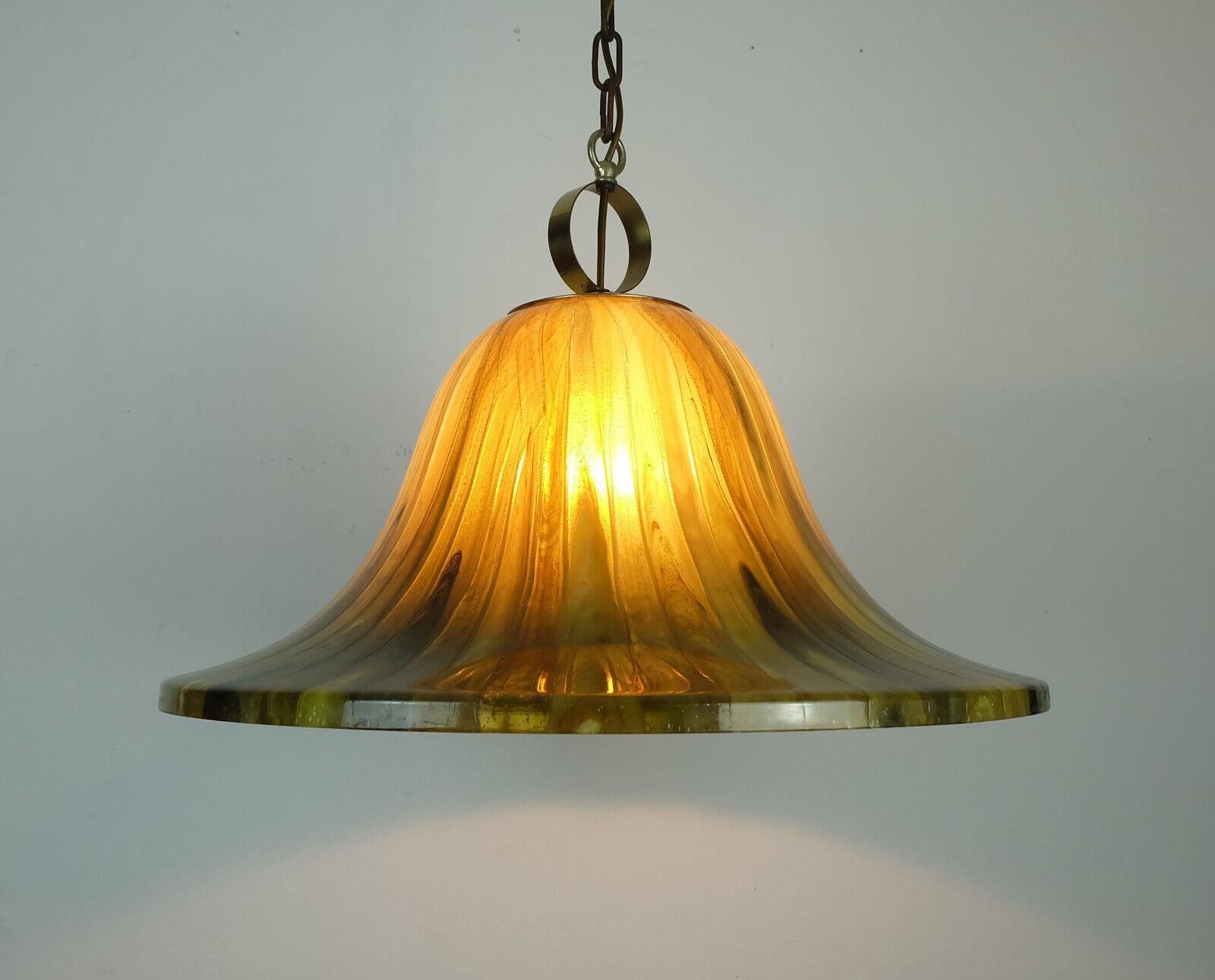 Impressive 1970s pendant light made of amber color acrylic and brass. For 1 bulb with E27 socket. 

Dimensions in cm:
Overall length 105 cm, diameter shade 51 cm, height shade 27 cm.

Dimensions in inches:
Overall length 41.33