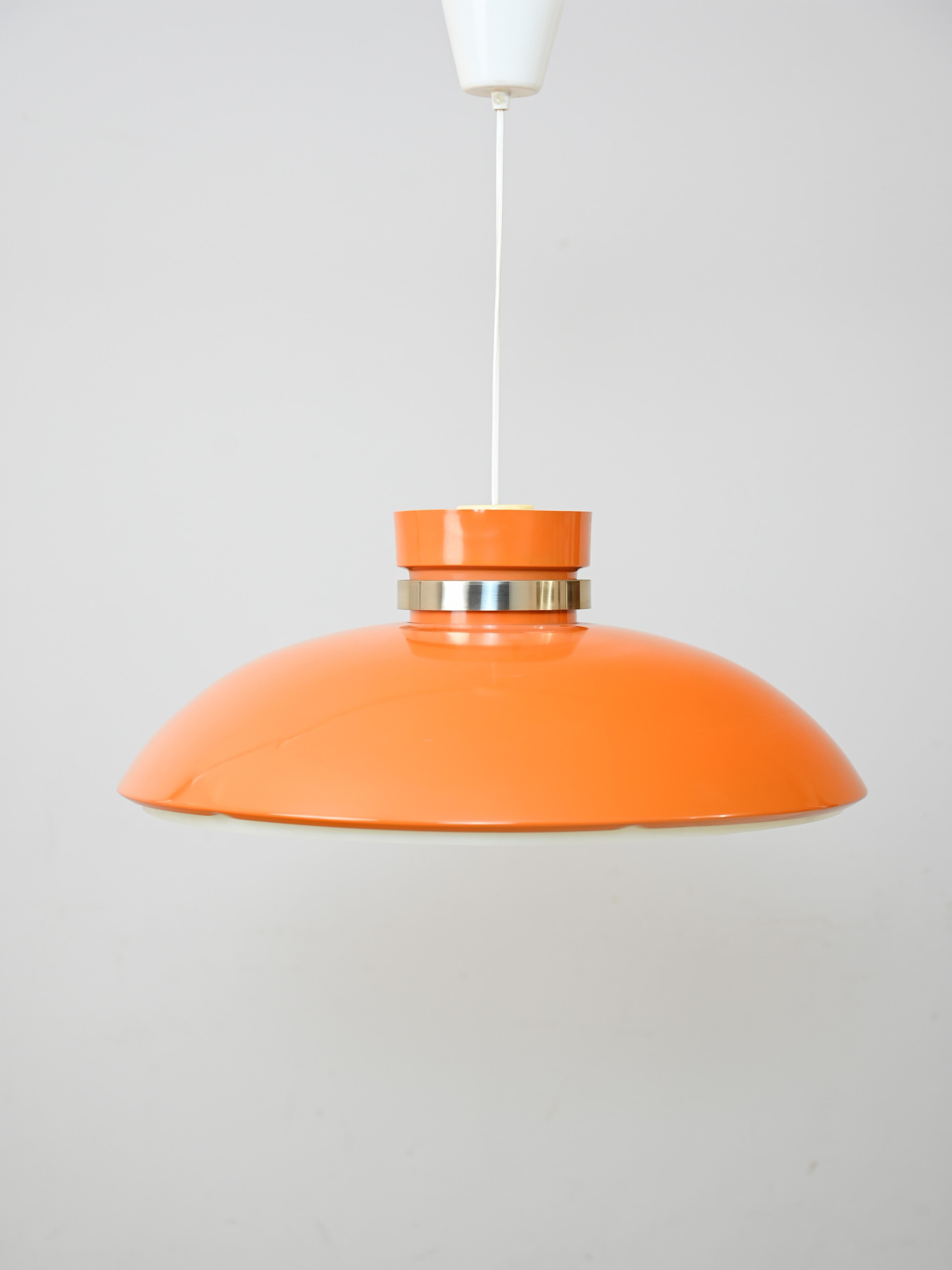 Original Scandinavian 1960s lamp with orange shade.

A modern antique piece with a simple design that is still relevant today. The color and choice of material hark back to mid-century taste. 
The lampshade is made of orange hard plastic and