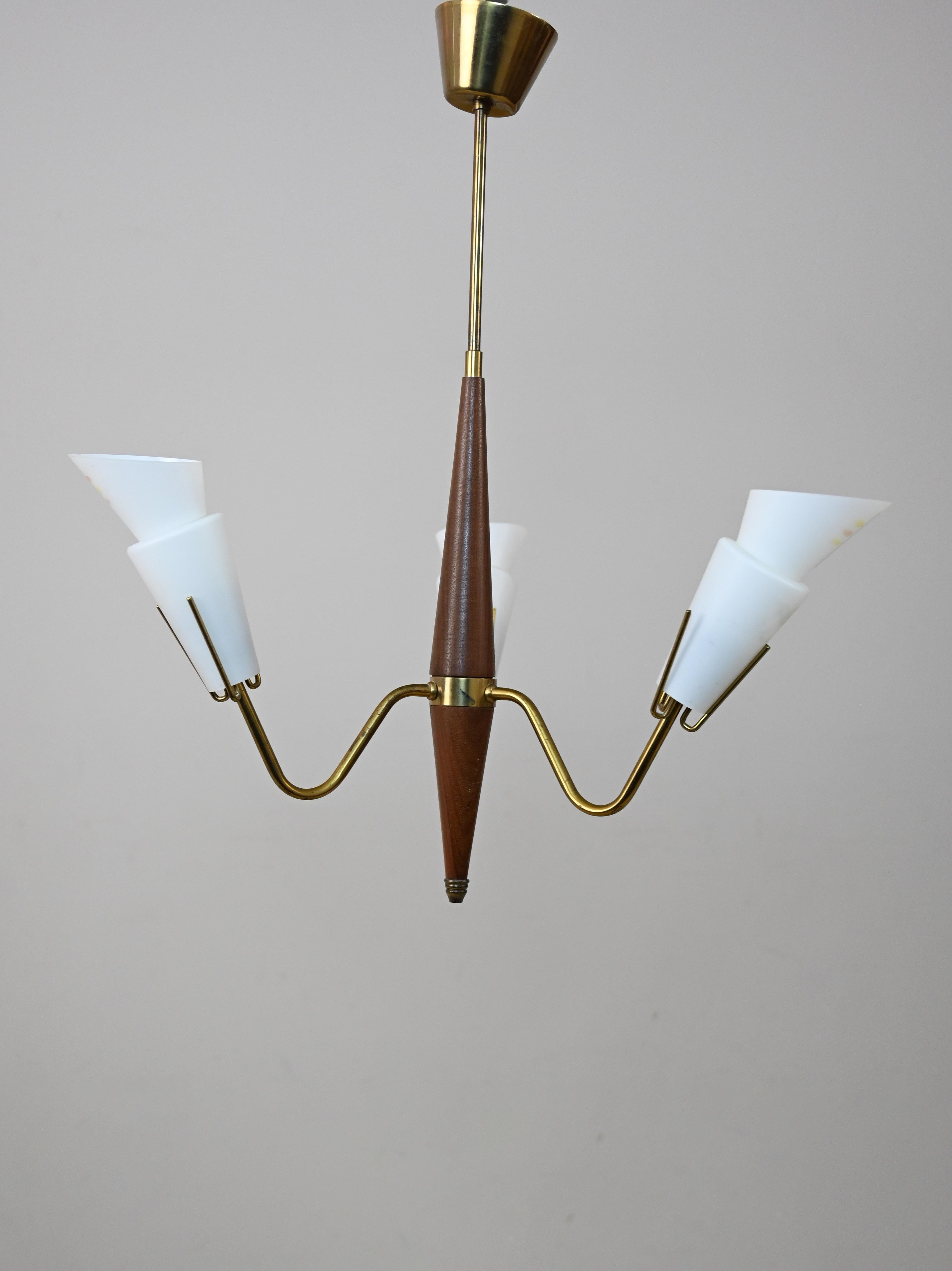Lamp with teak frame and 3 lights.

This Scandinavian modernist furnishing accessory traces mid-century style and taste.
The original and elegant form consists of a teak frame with three brass arms to which the 3 lights with decorated opaline glass