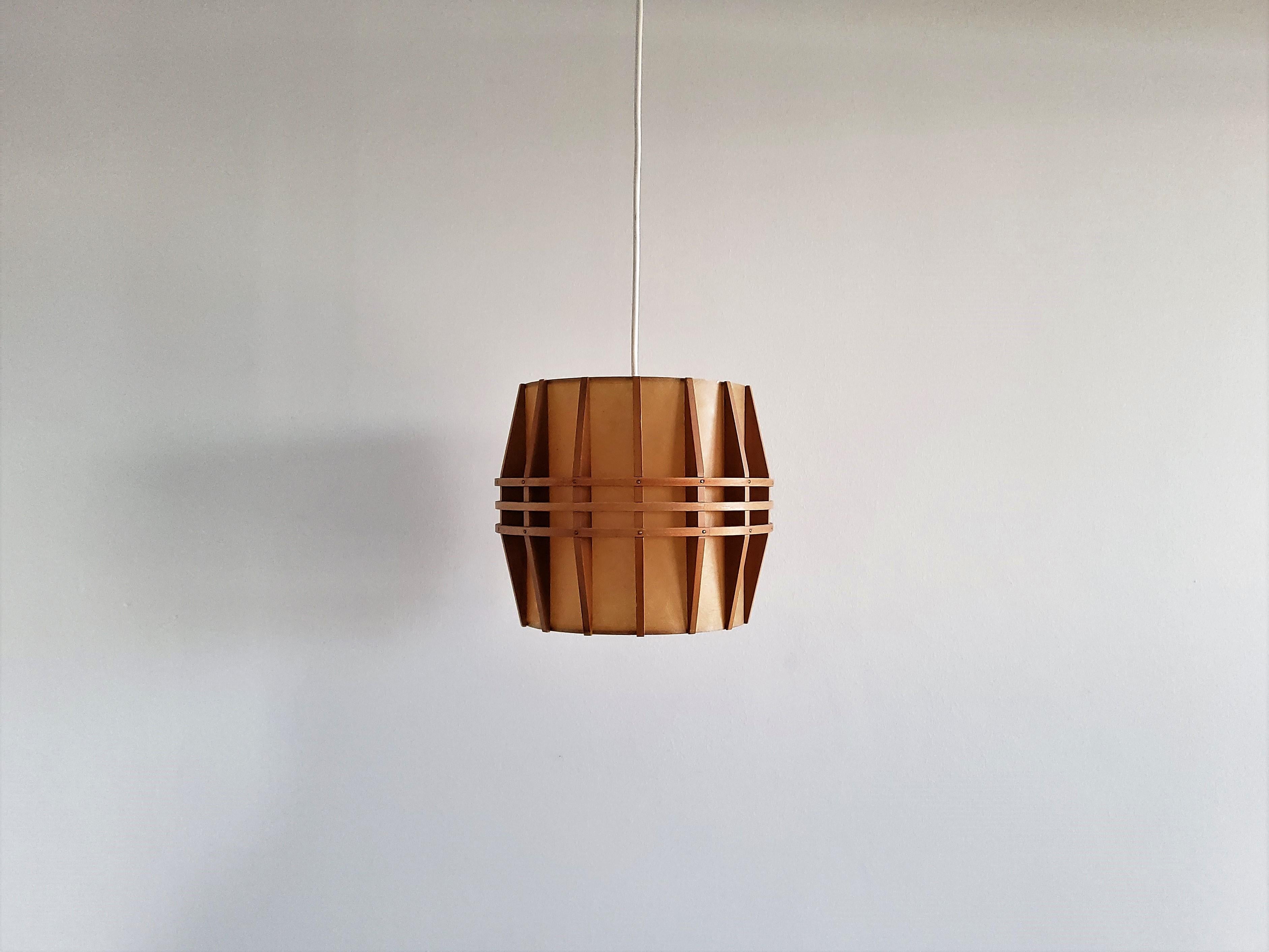 This is a very nice vintage pendant lamp from the 1960's, imported from Denmark. It has a cocoon shade, surrounded with small and narrow wooden slats. The design makes this lamp giving a nice warm and diffused light. All in a very good condition,